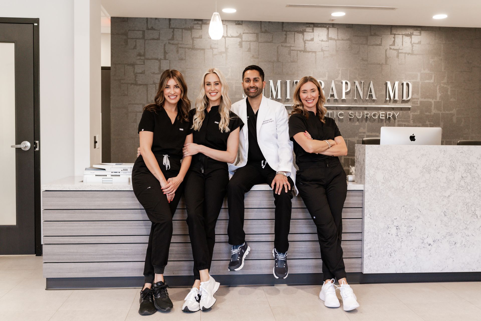 A group of people are sitting on a counter in a hospital.