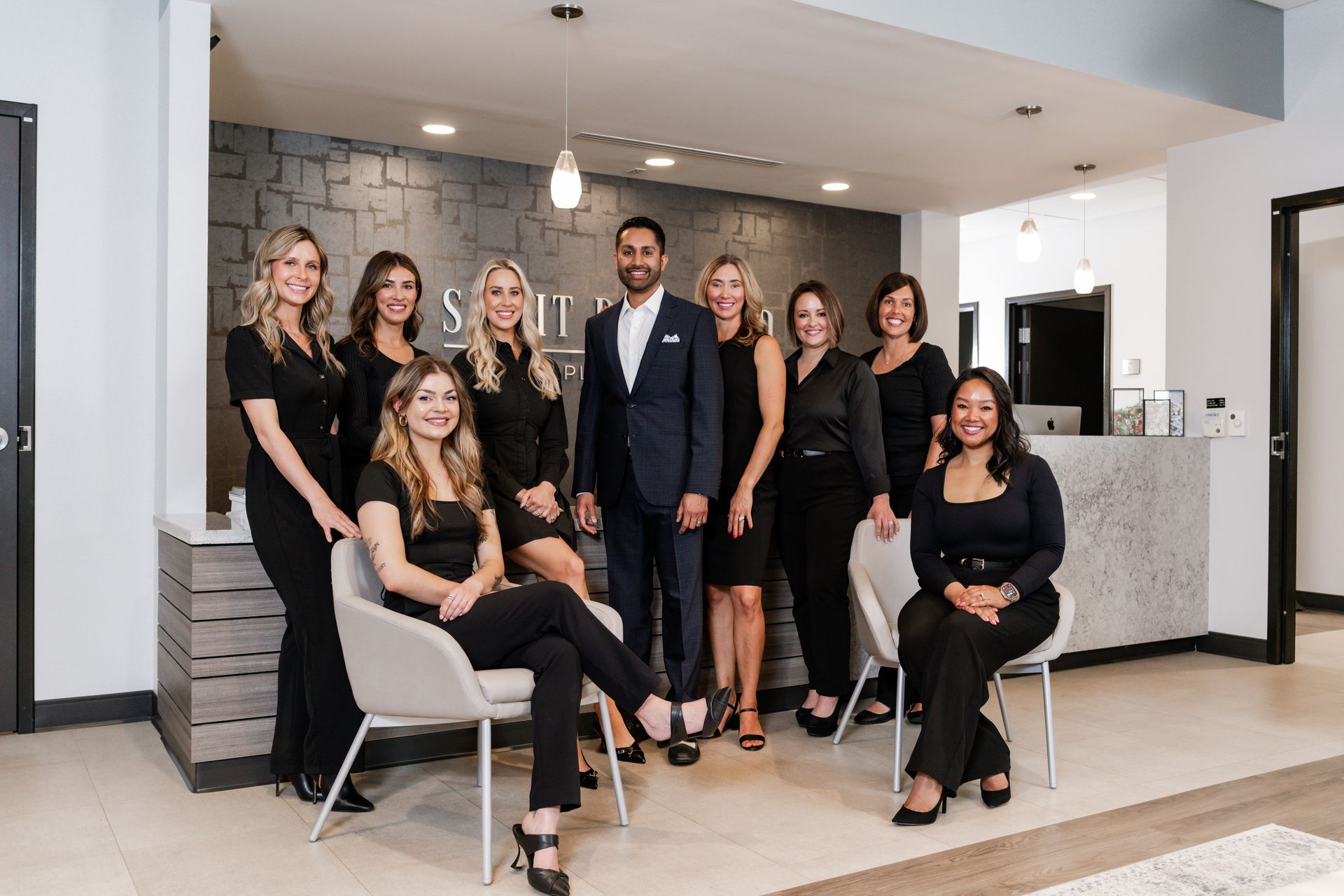 A group of people are posing for a picture in a dental office.