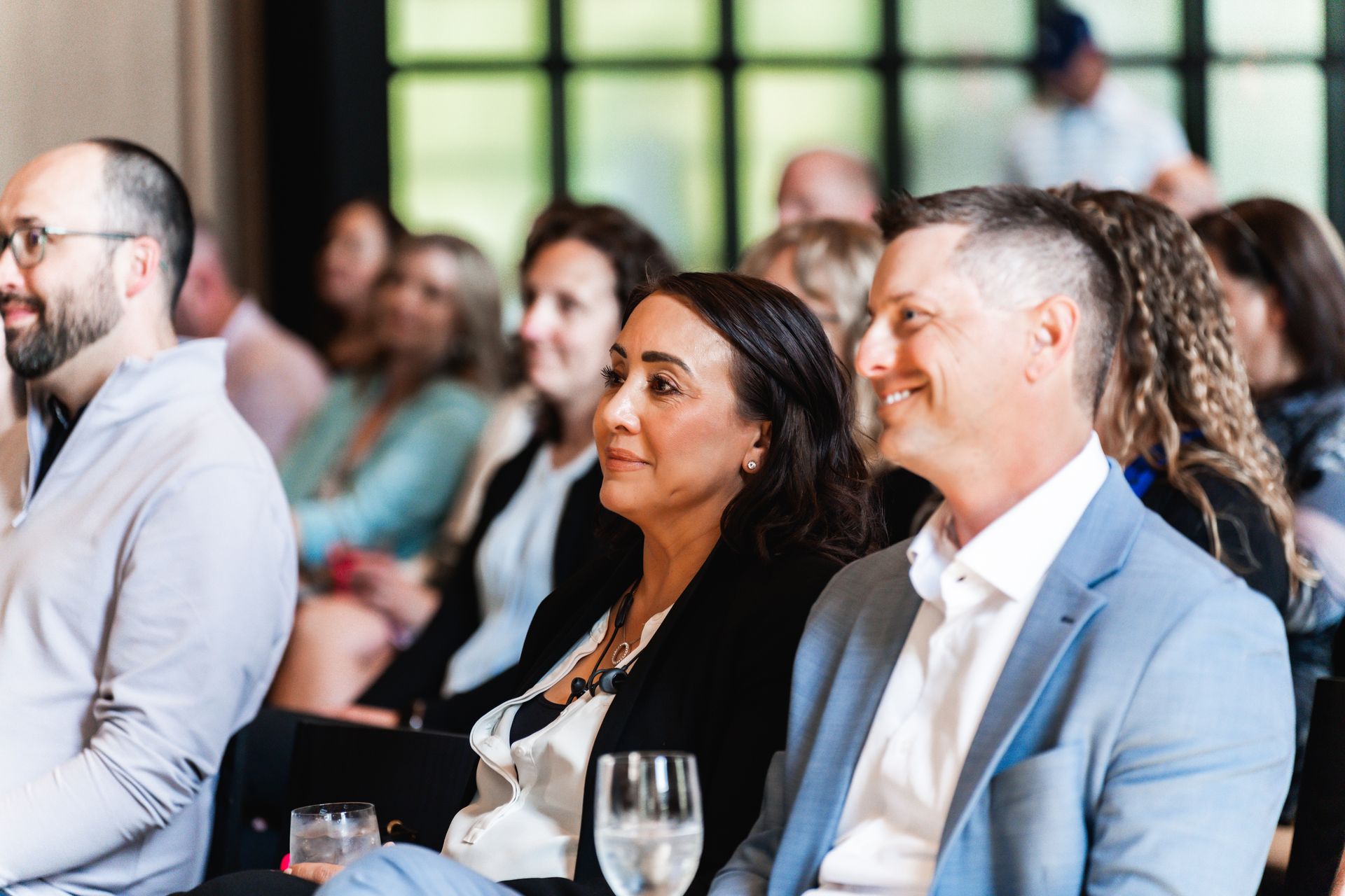 A group of people are sitting in a room watching a presentation.