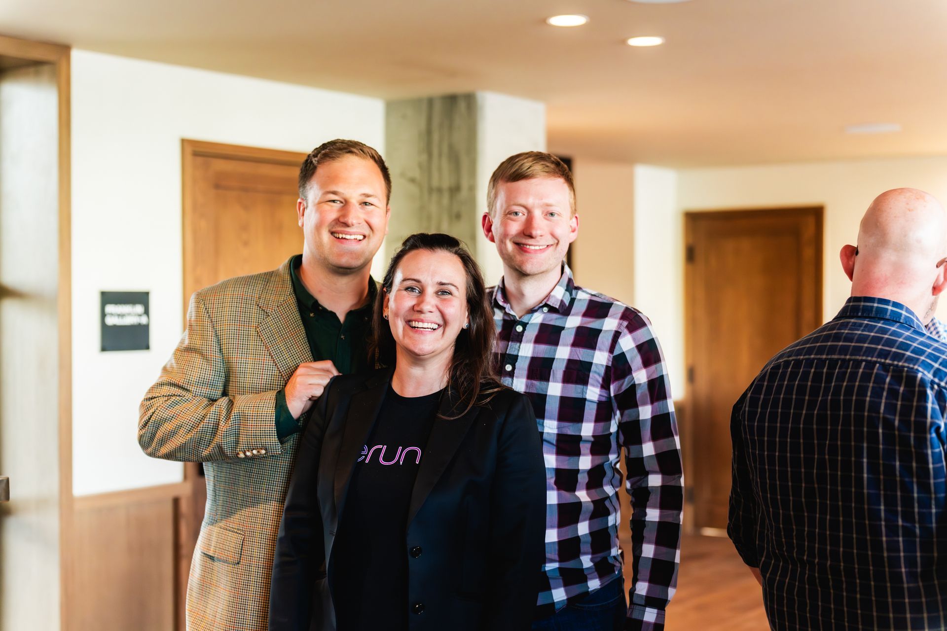 A group of people are posing for a picture in a hallway.