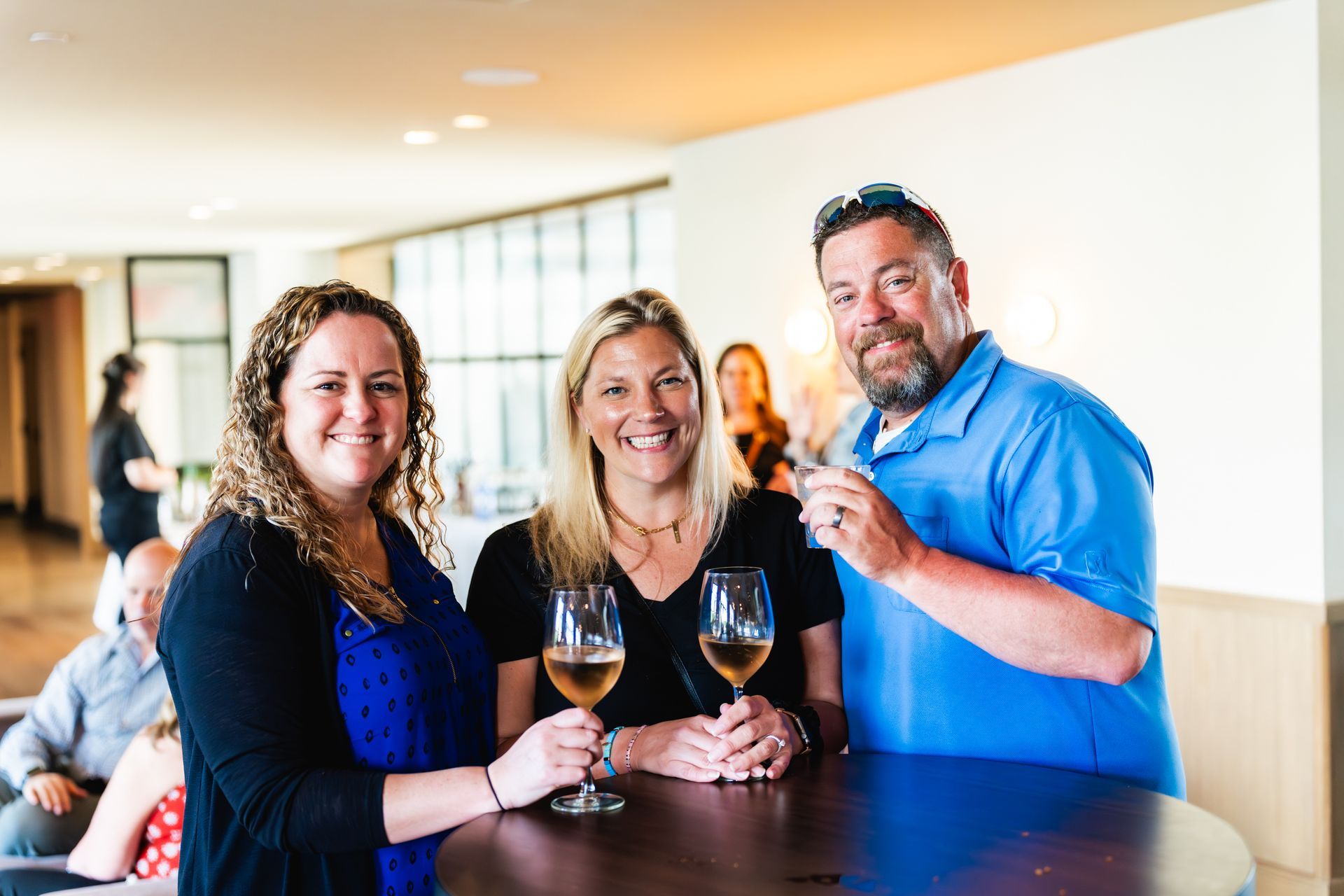 A group of people are sitting at a table holding wine glasses.