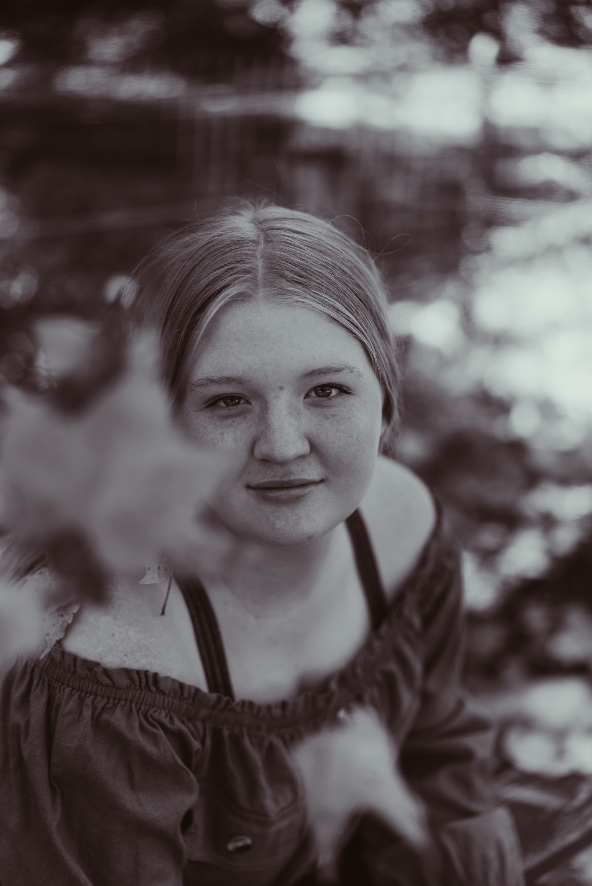 a girl is sitting on a bench with her arm resting on the arm rest