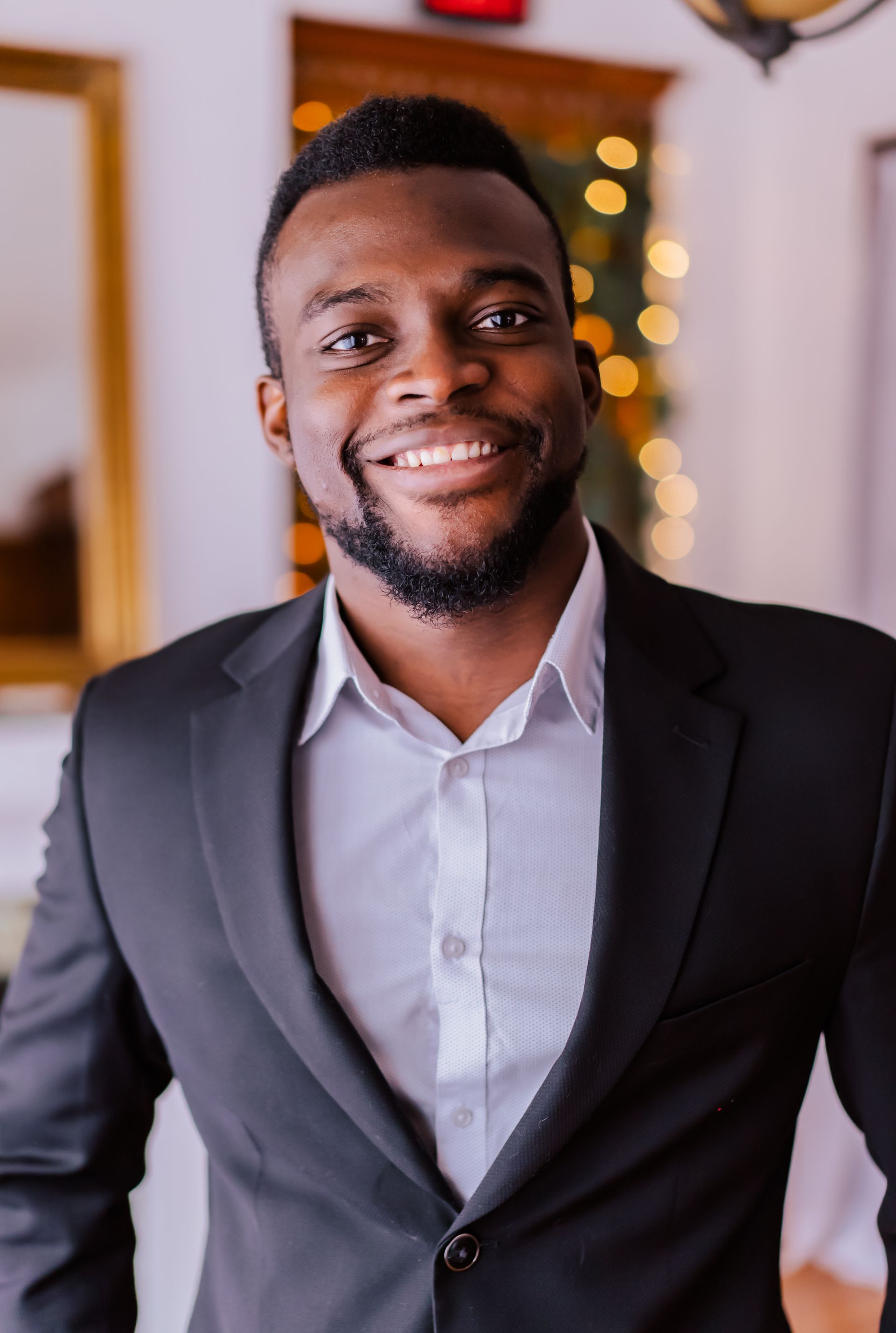 a woman in a purple dress is standing in front of a christmas tree .