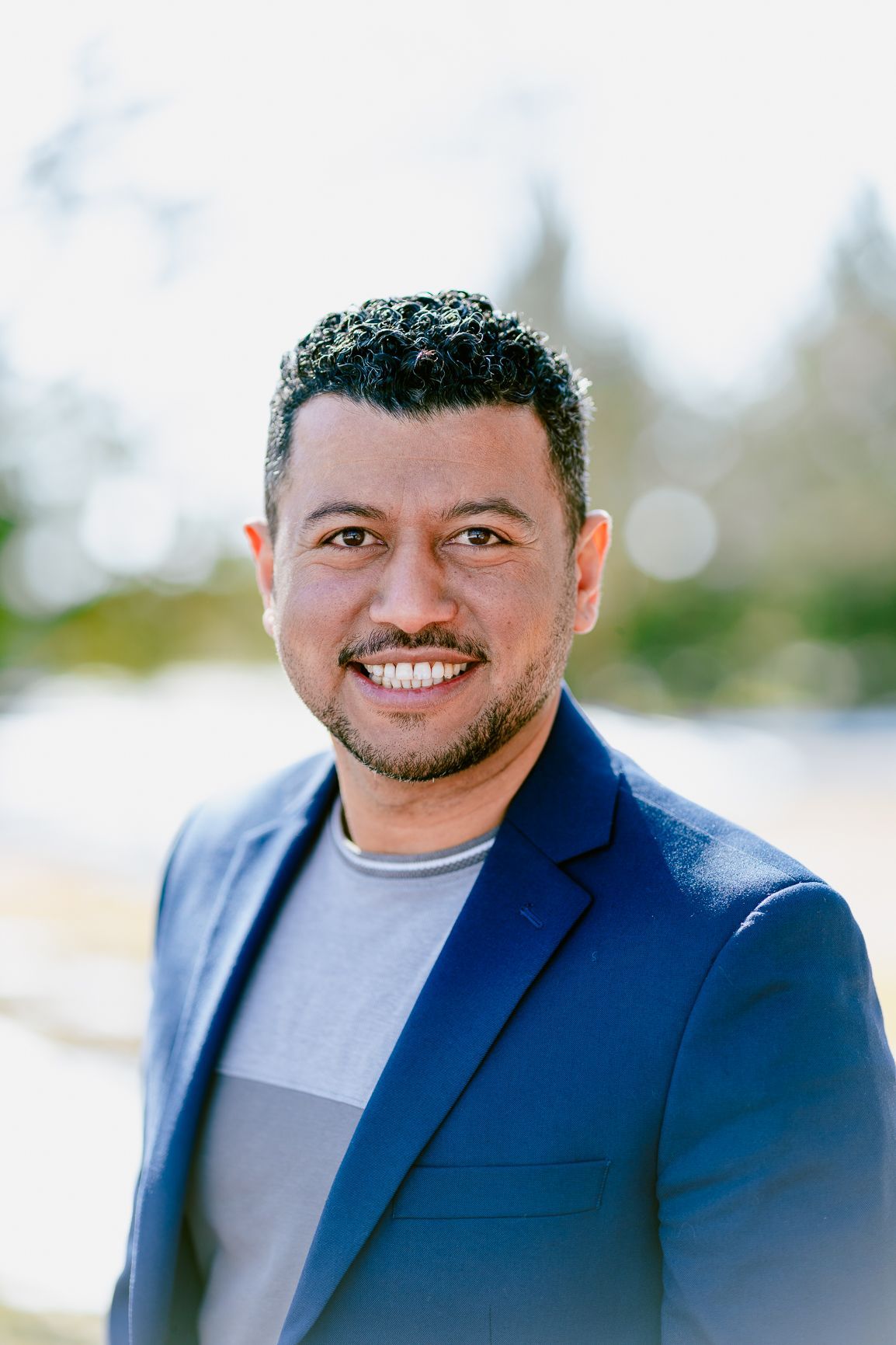 a woman in a purple dress is standing in front of a christmas tree .
