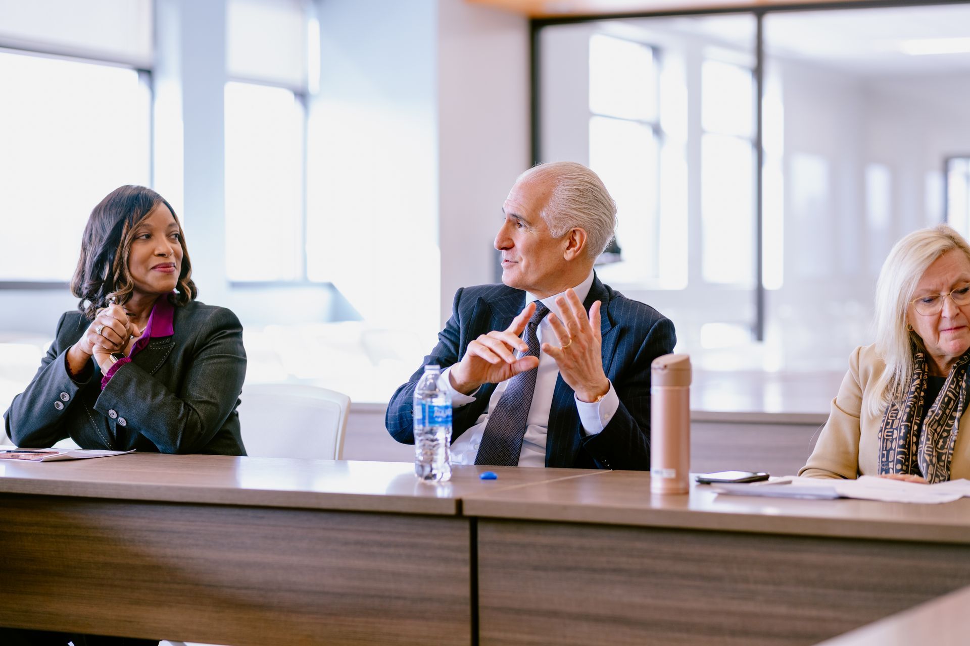 A group of people are sitting at a table in a conference room.