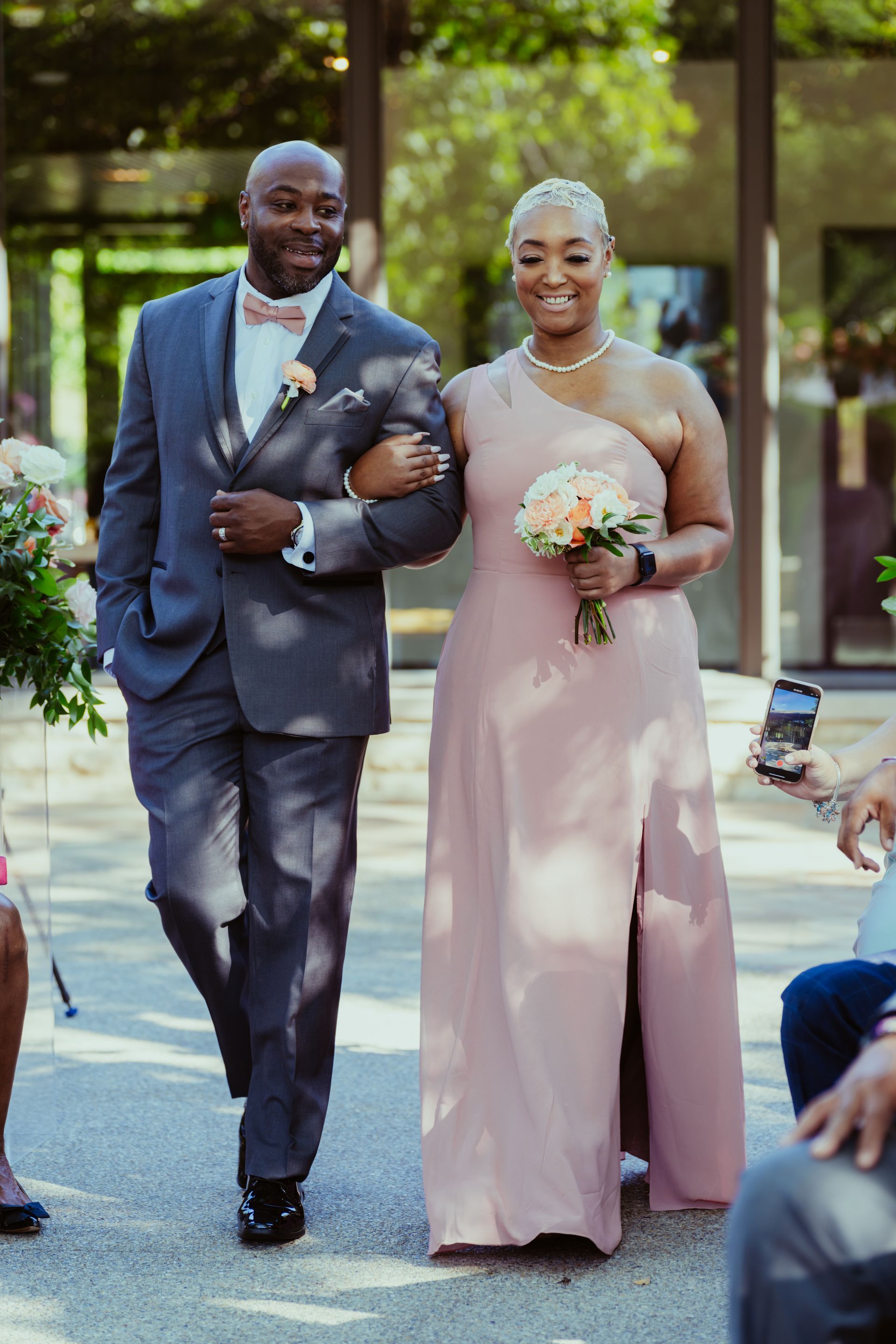 A bride and groom are walking down the aisle at a wedding.