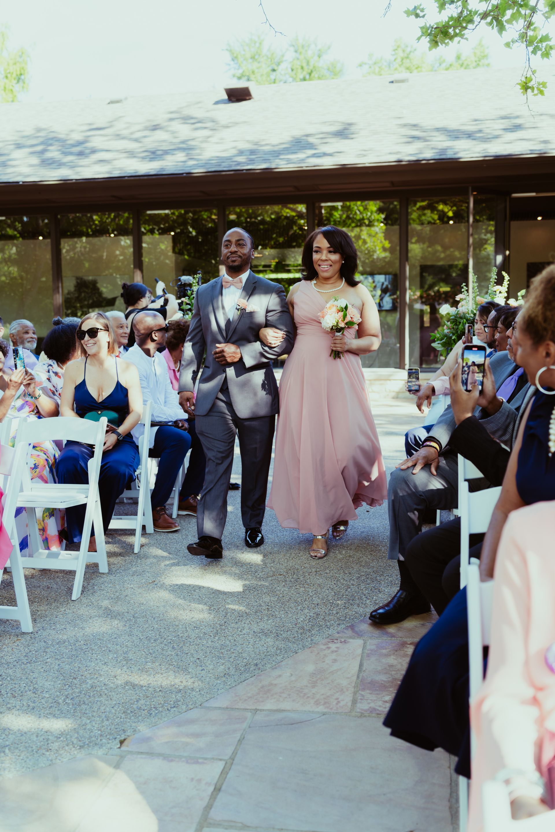 A bride and groom are walking down the aisle at a wedding