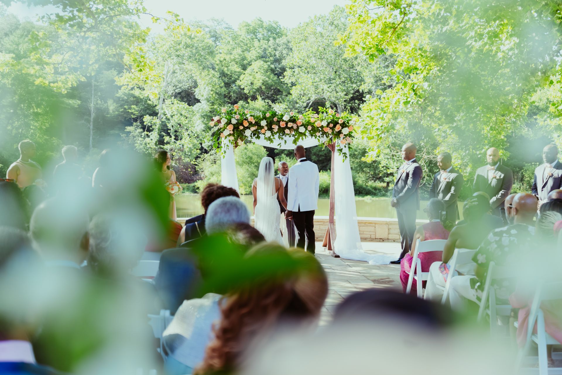 A bride and groom are getting married in front of a crowd of people at a wedding ceremony.