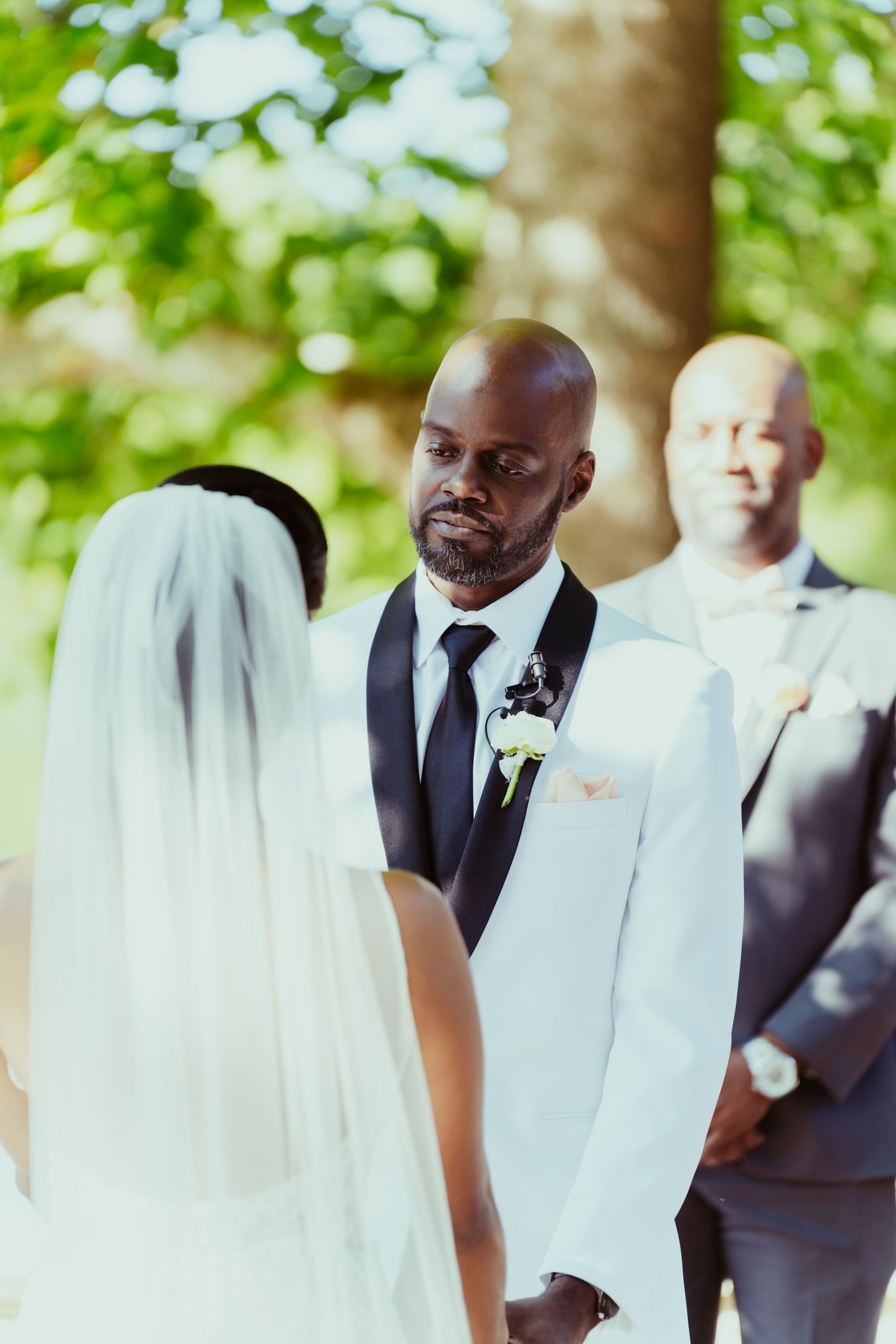 A bride and groom are holding hands during their wedding ceremony.