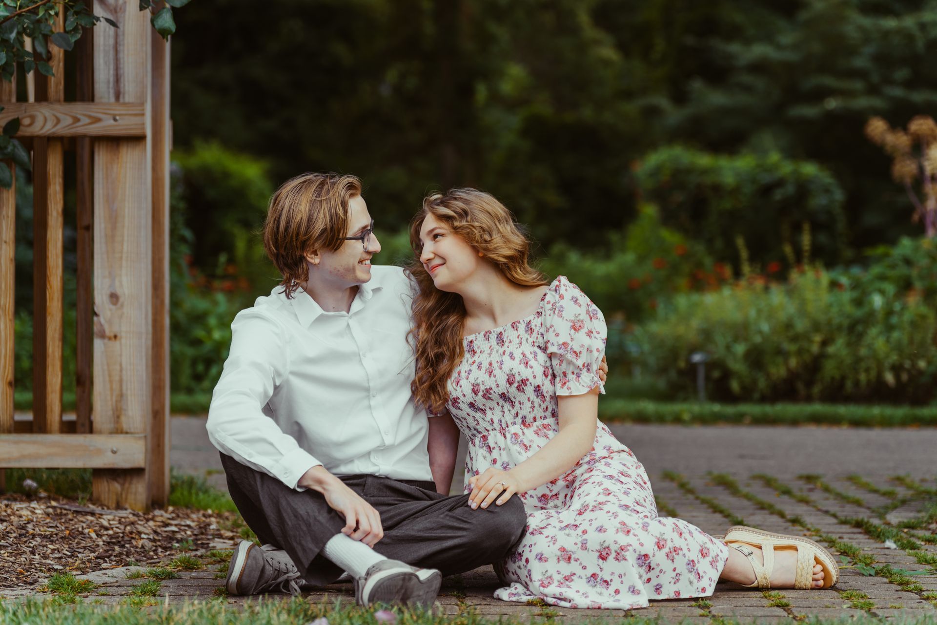 A man and a woman are sitting on the ground looking at each other.