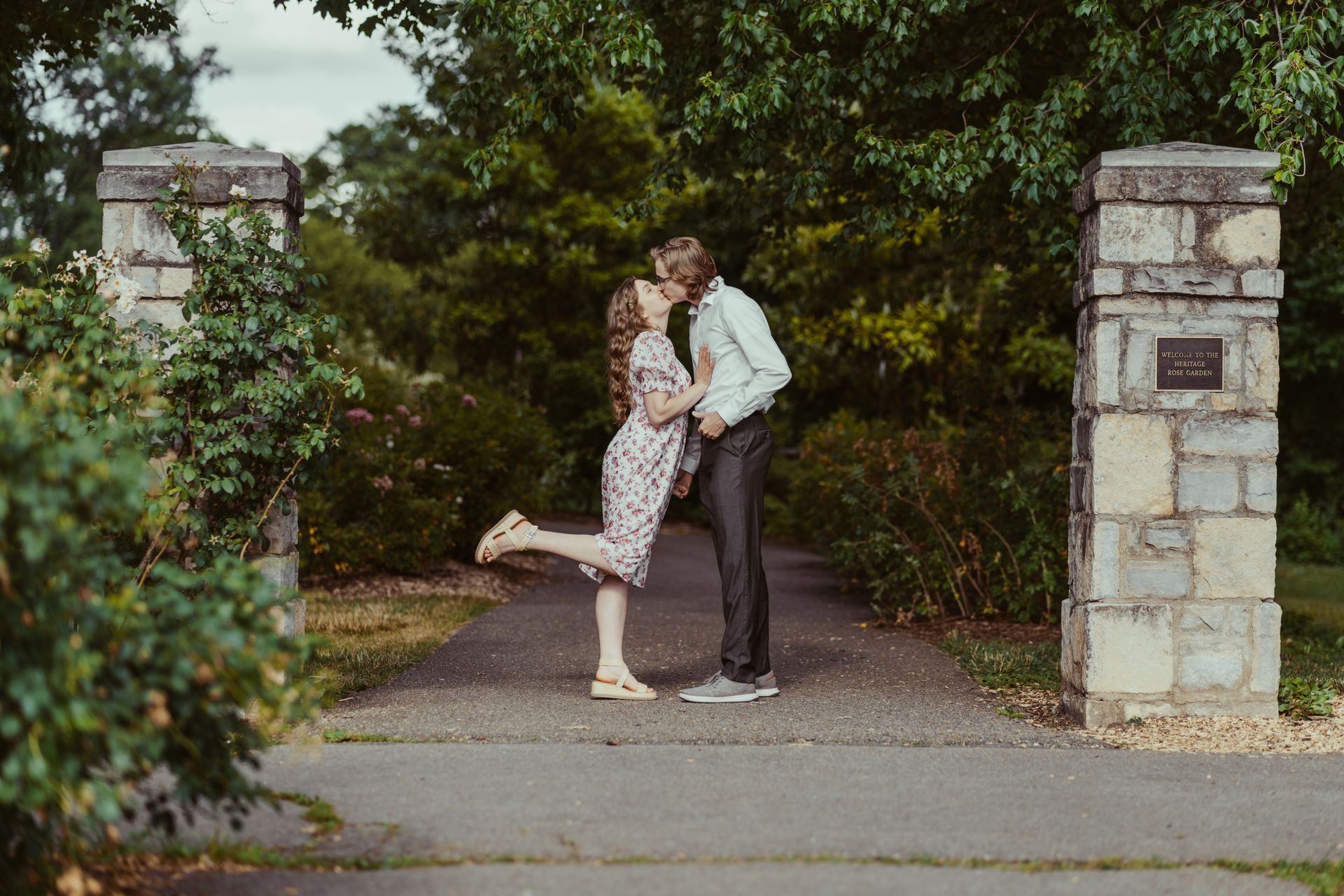 A man and a woman are kissing in a park.
