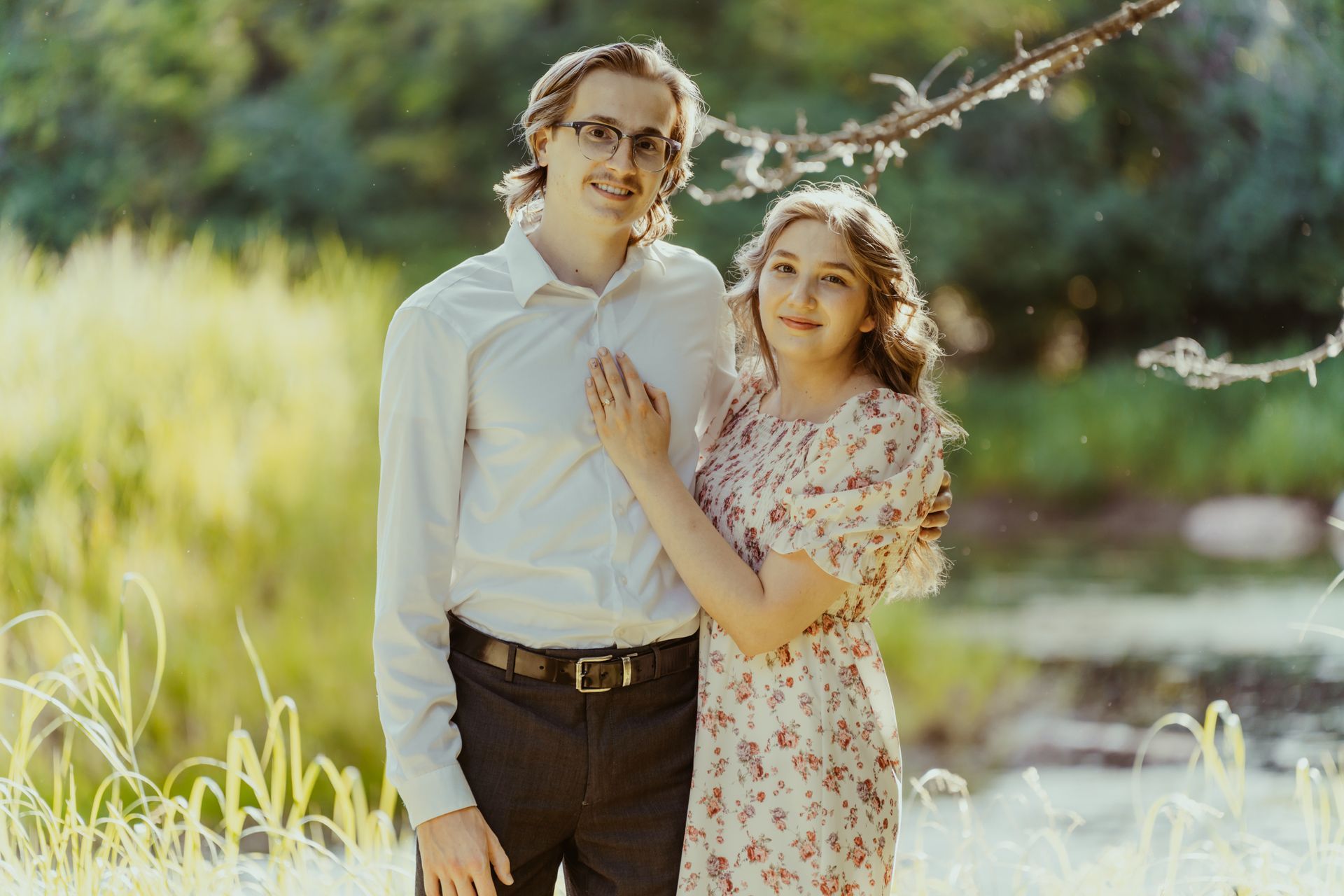 A man and a woman are standing next to each other in a field.