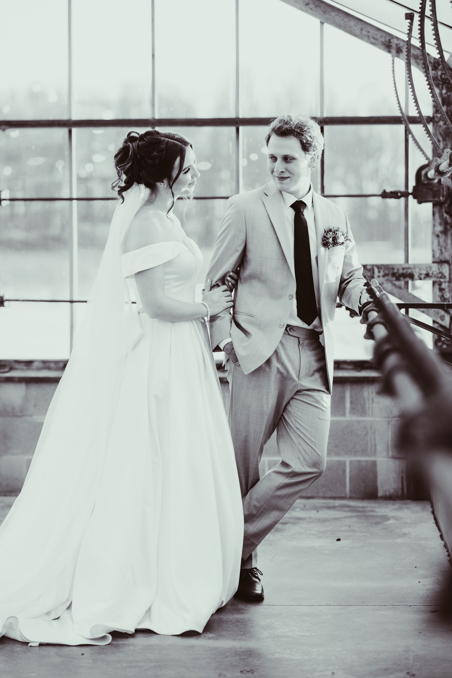 Wedding couple in formal attire, looking at each other, in a greenhouse setting. Black and white | Jorgensen farms oak grove
