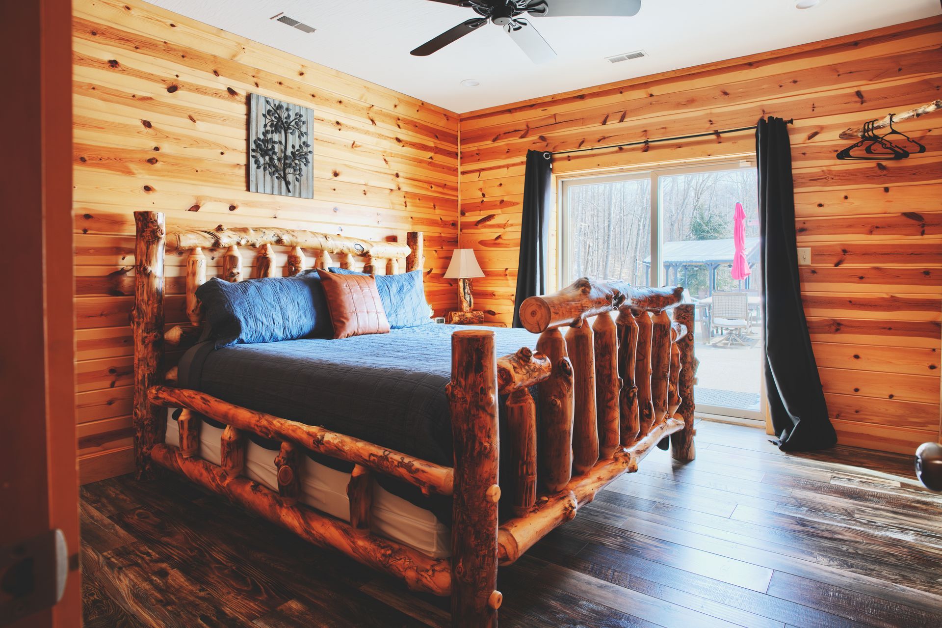 A bedroom with a log bed and a ceiling fan.