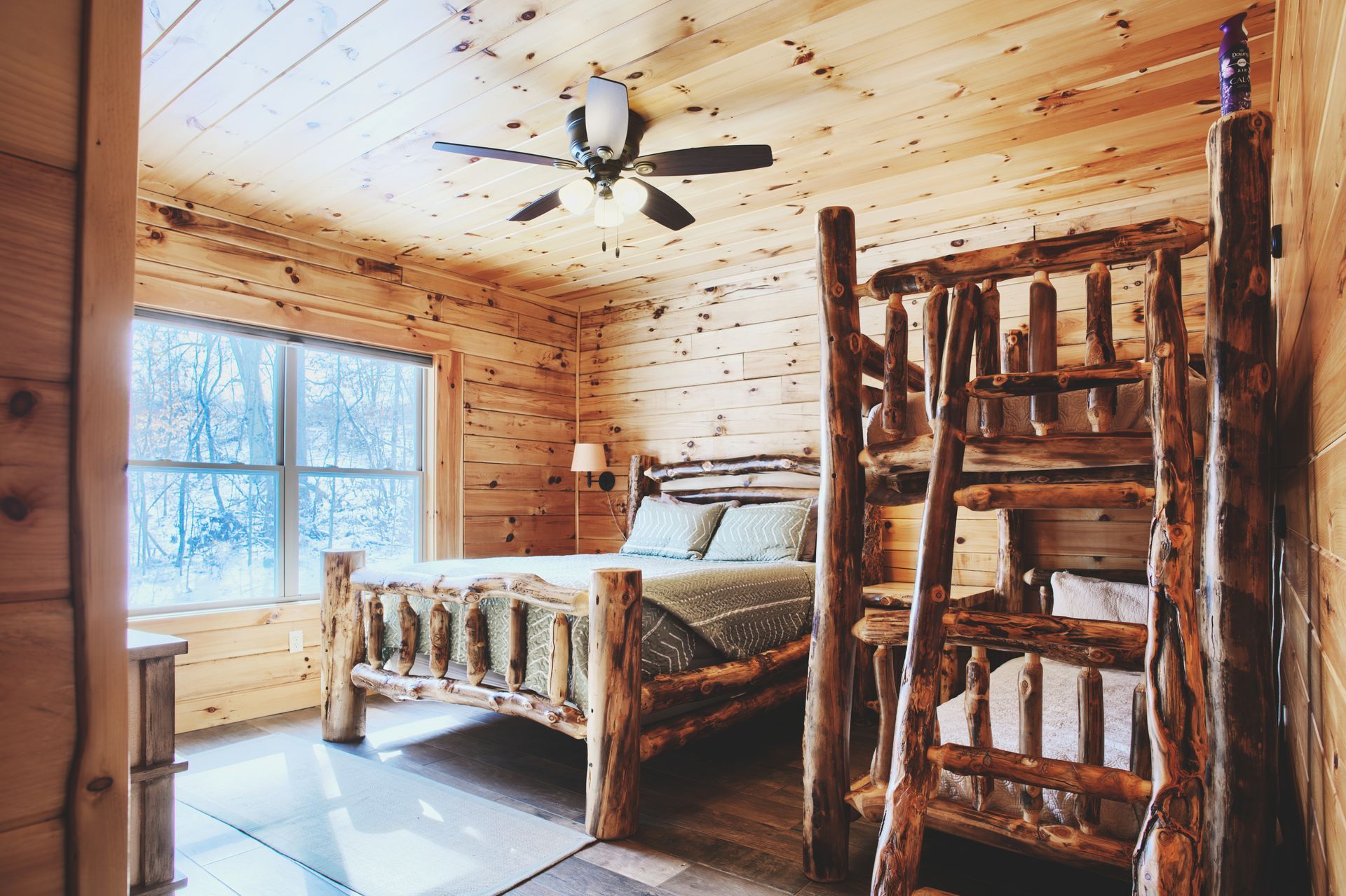 A bedroom in a log cabin with a bed and bunk beds