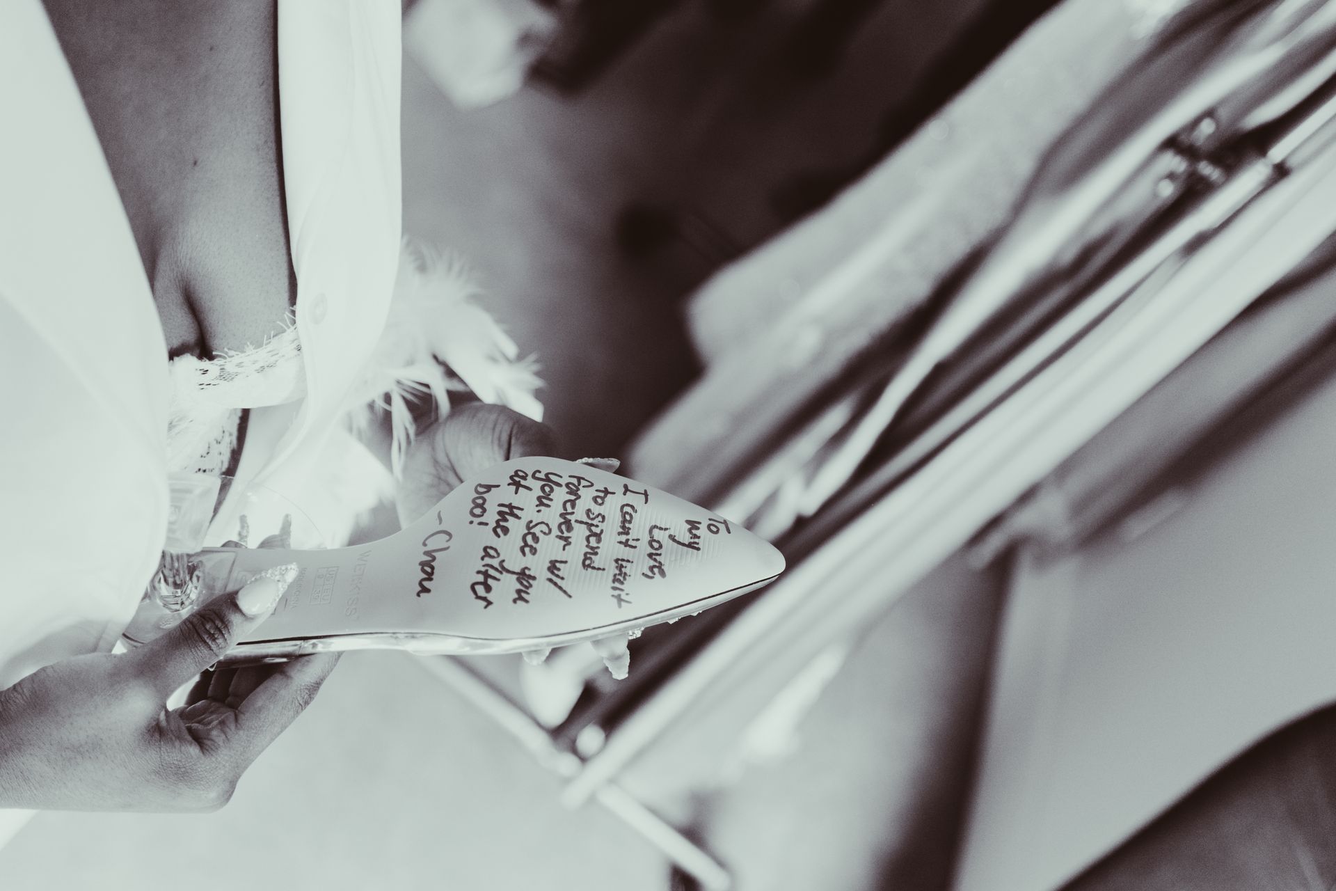 A black and white photo of a woman holding a pair of shoes
