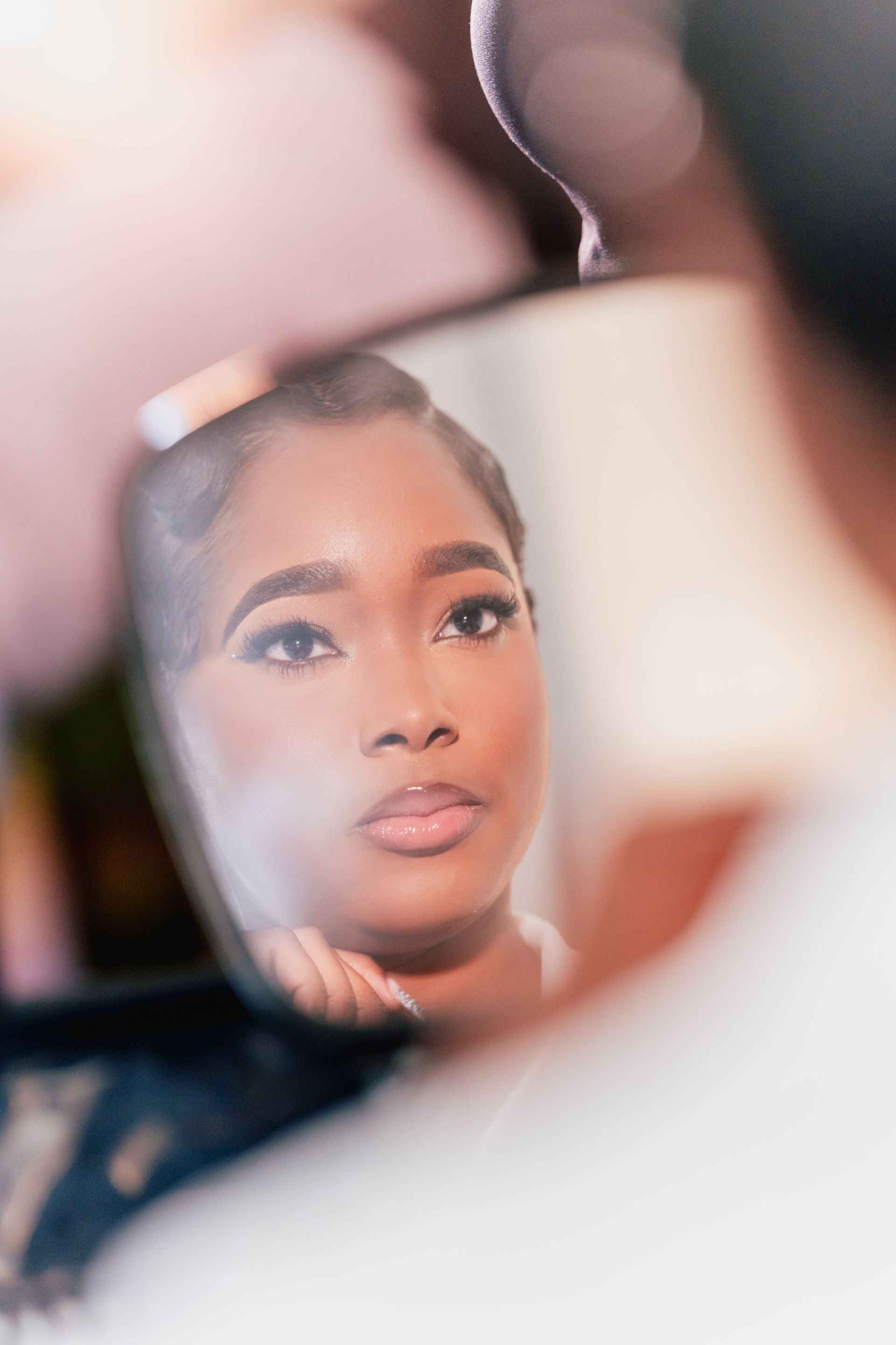 A bride is looking at her reflection in a mirror.