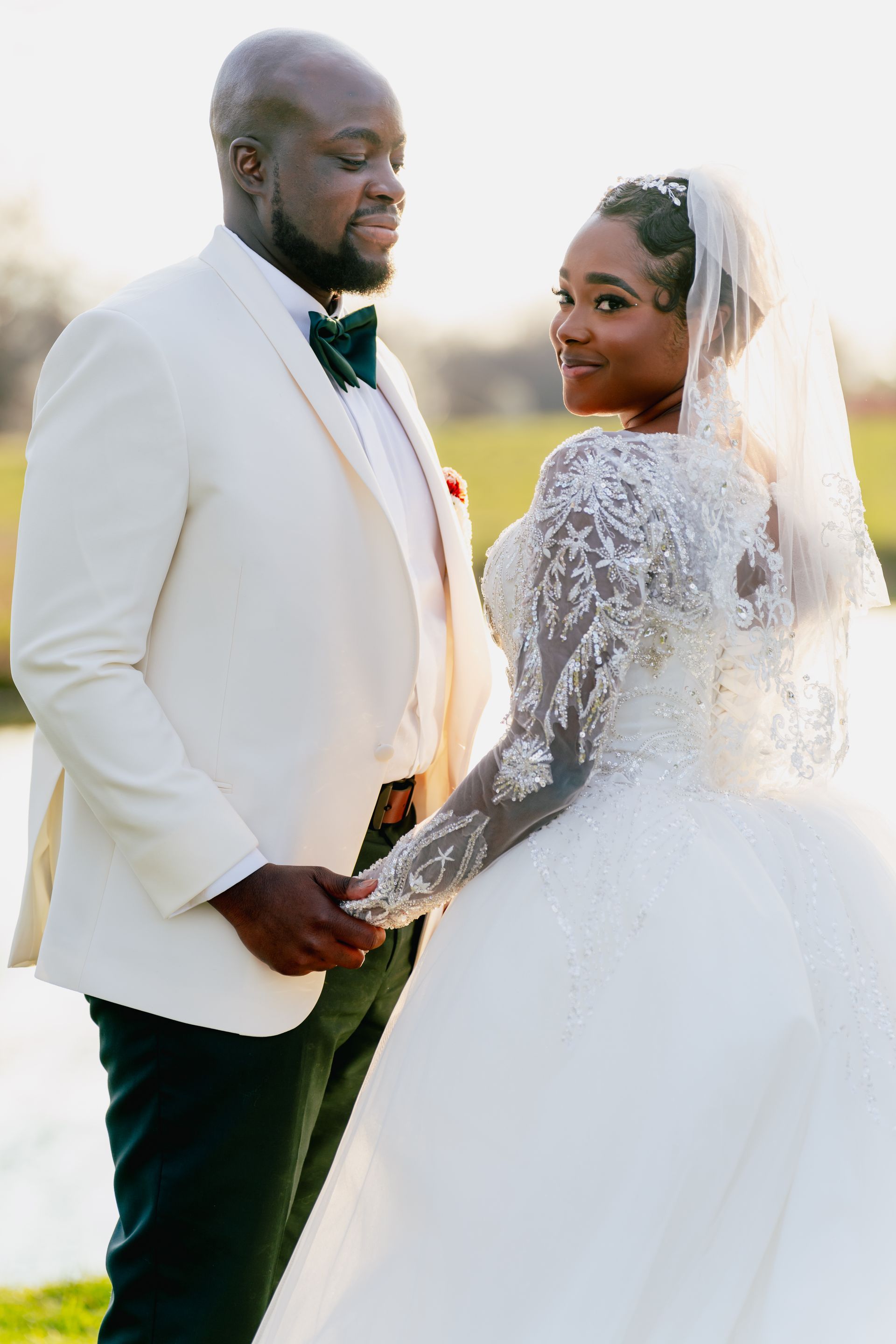 A bride and groom are standing next to each other holding hands.