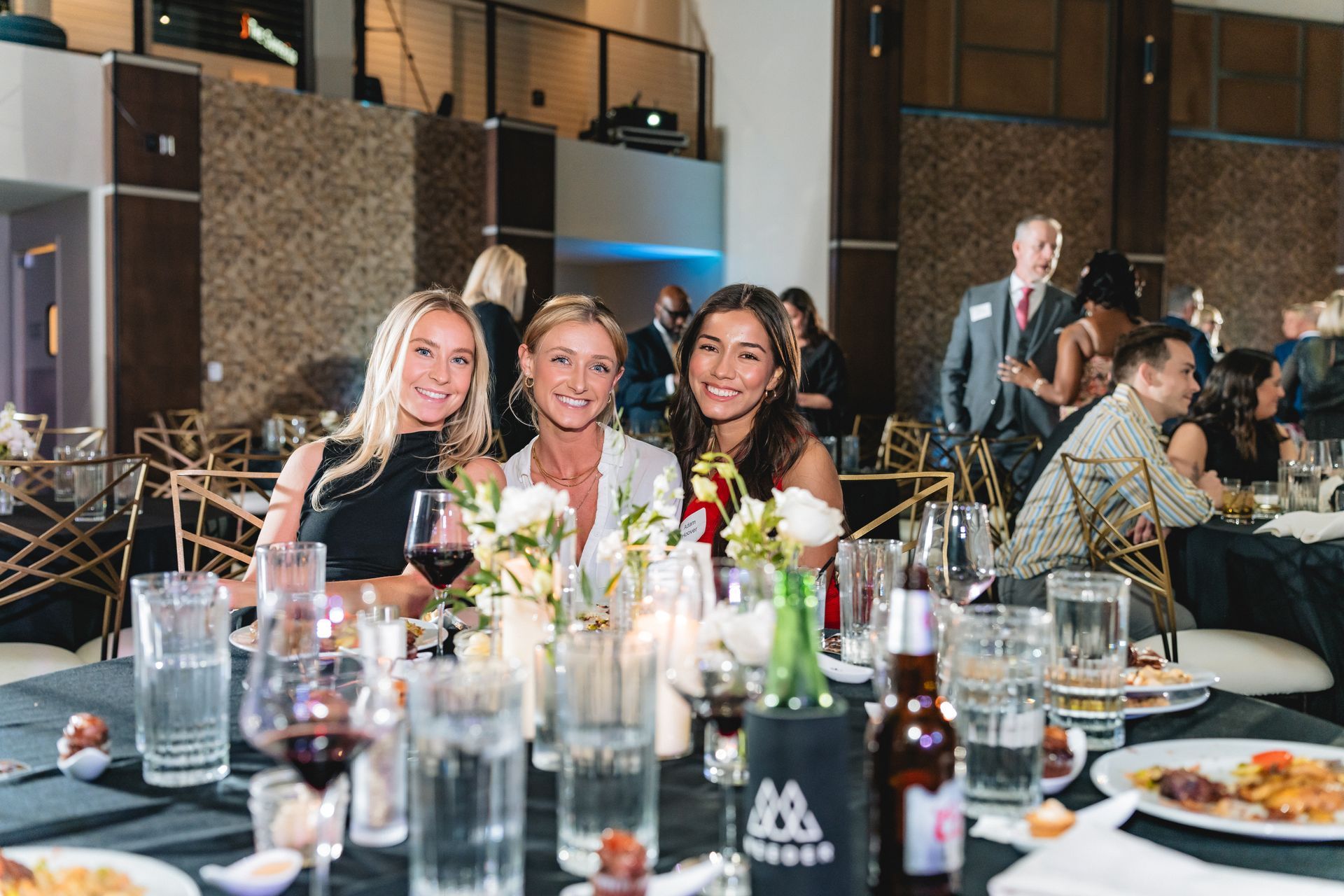 A group of women are sitting at a table at a dinner party.