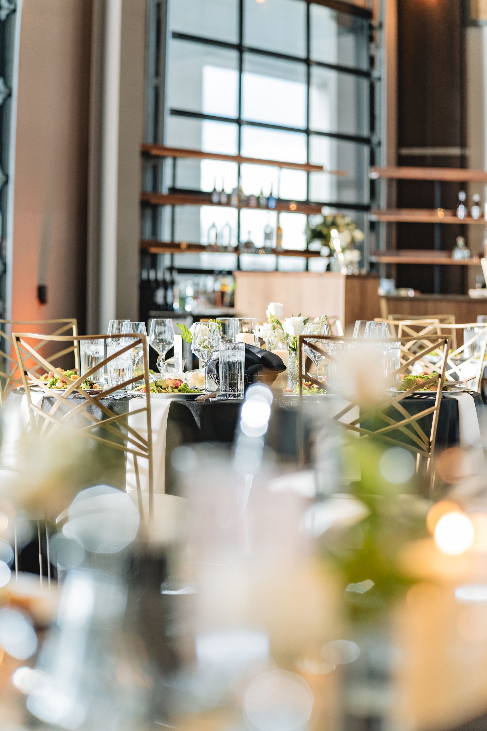 A table set for a wedding reception with flowers and candles on it.