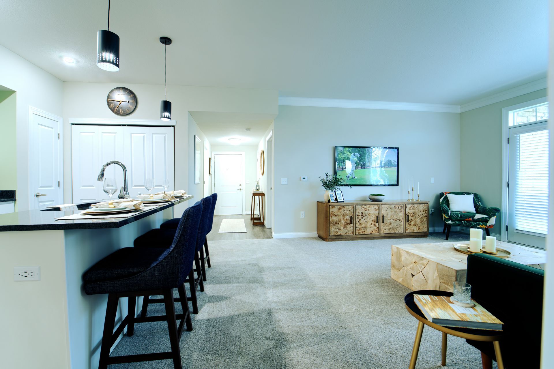 A living room with a couch , chairs , a table and a television.