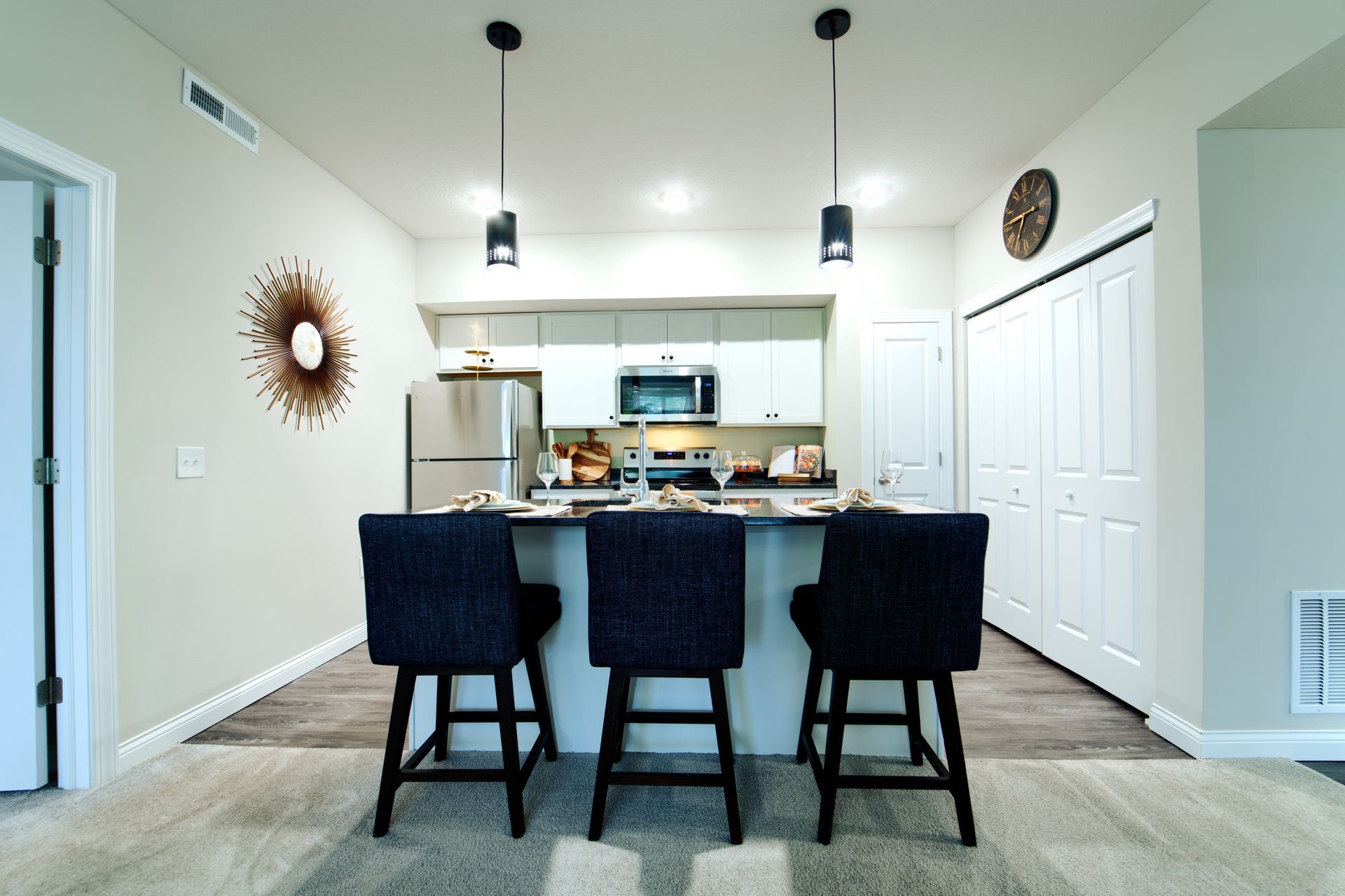 A kitchen with a large island and three chairs
