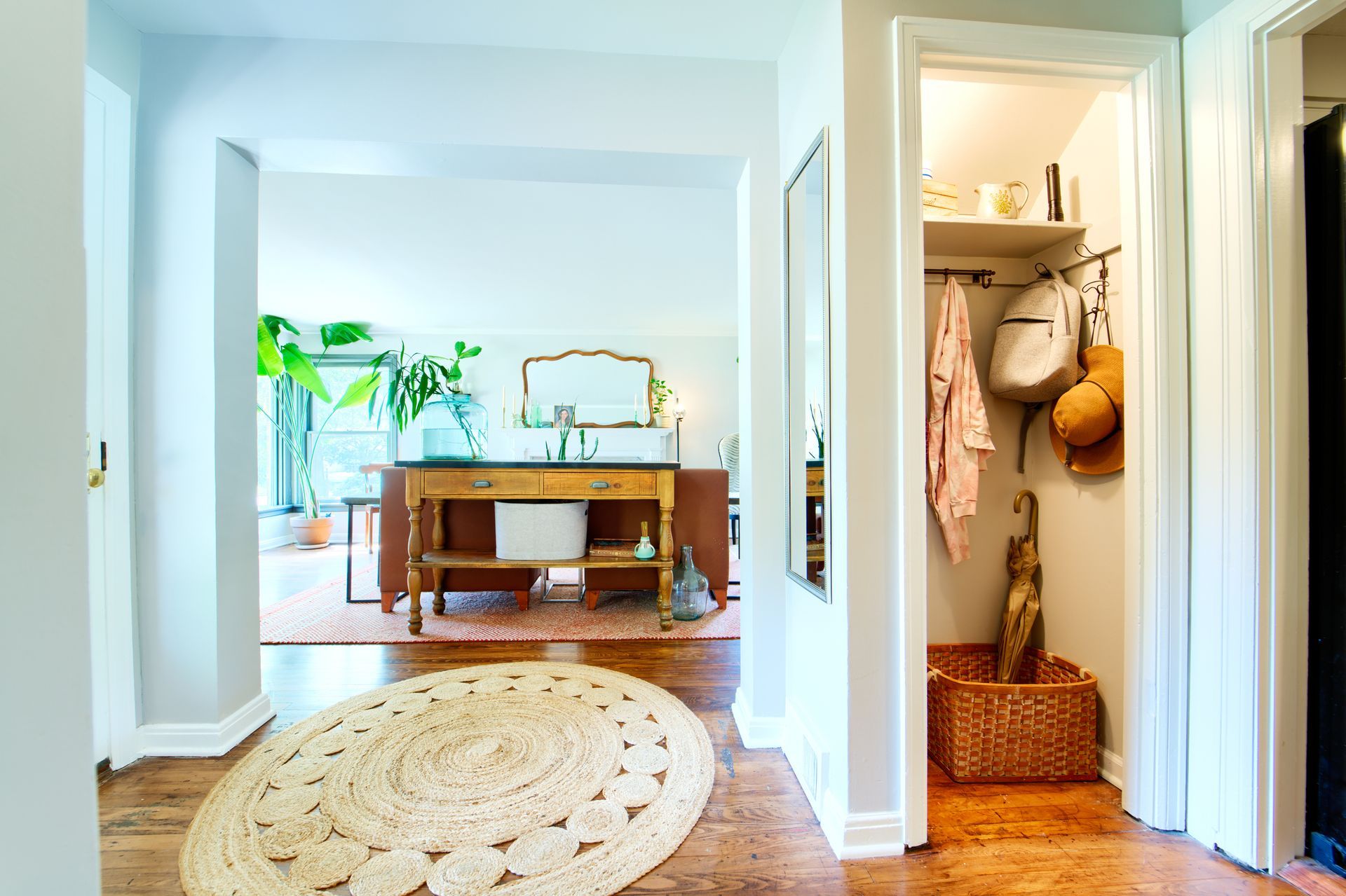 A hallway with a rug and a closet in a house.