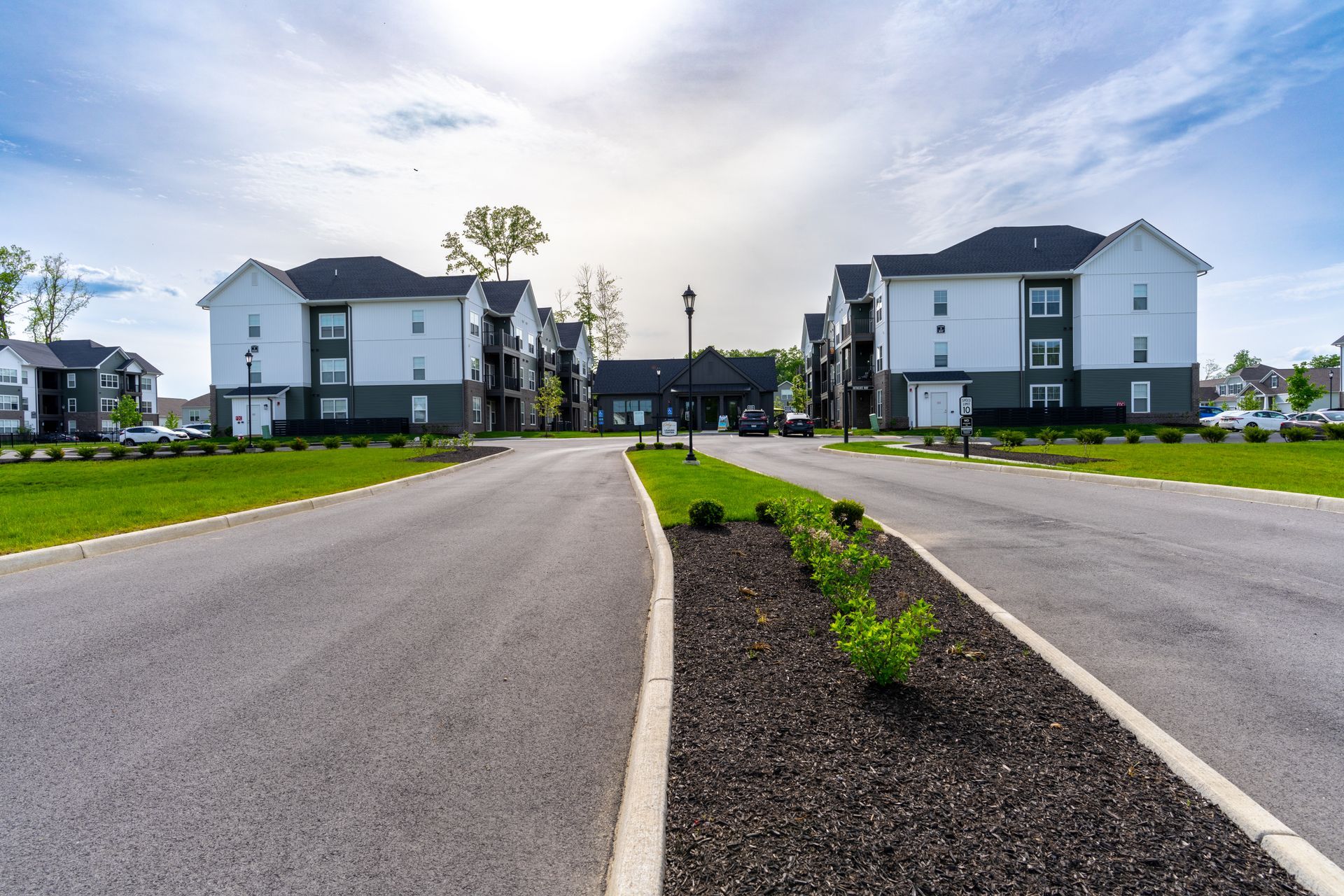 A road leading to a row of apartment buildings.