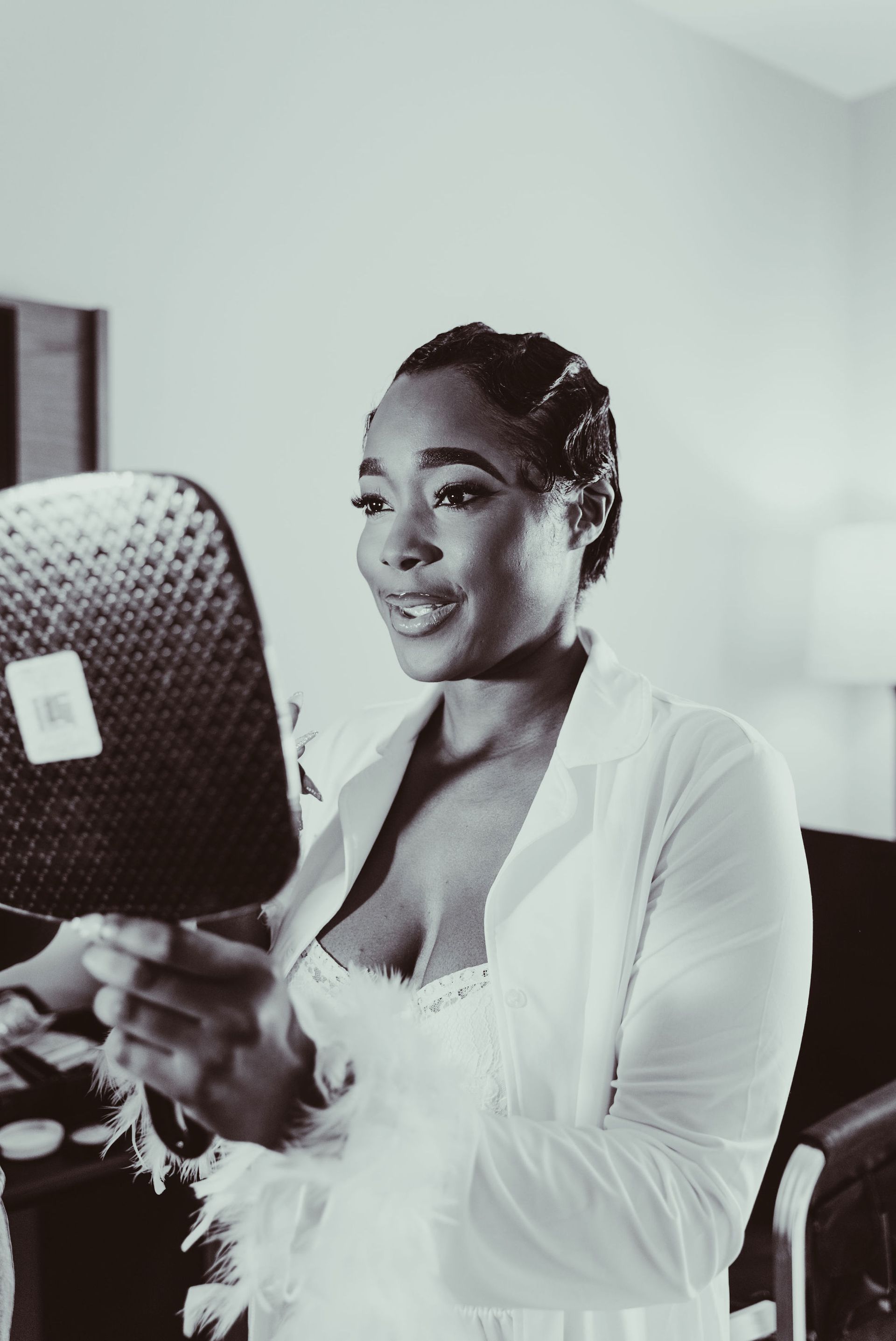 A black and white photo of a woman looking at herself in a mirror.