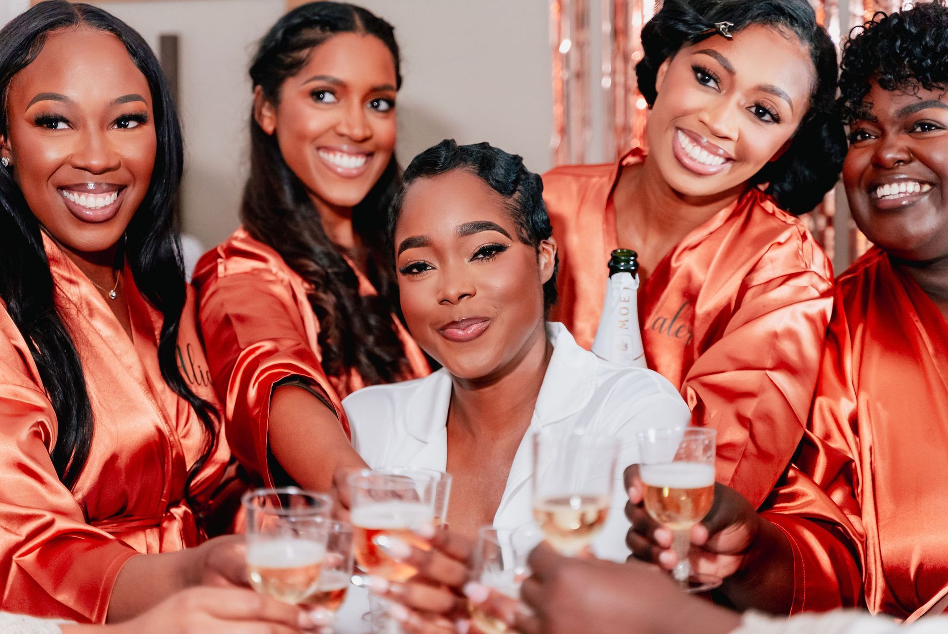 A bride and her bridesmaids are toasting with champagne.