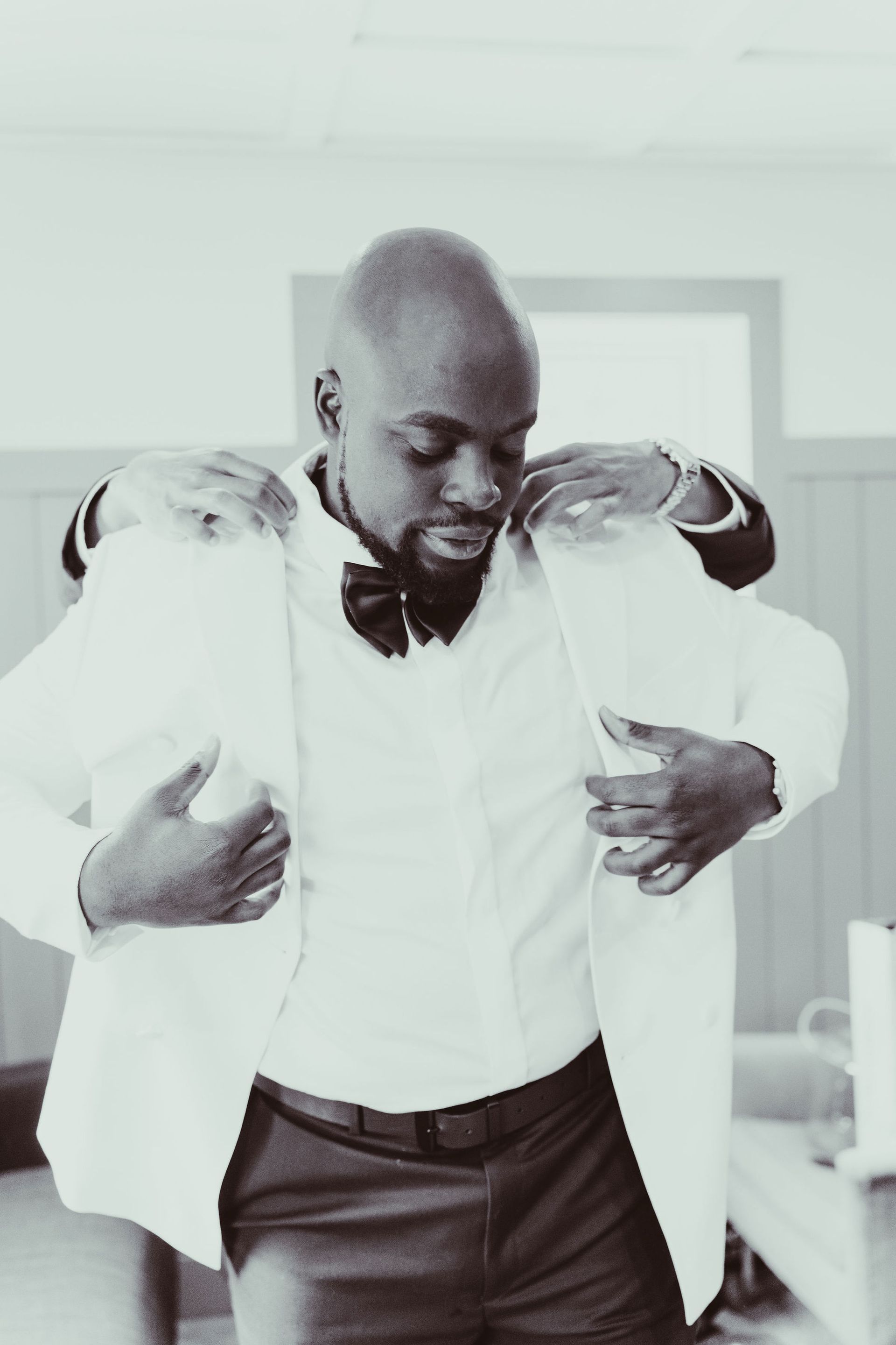 A black and white photo of a man in a tuxedo