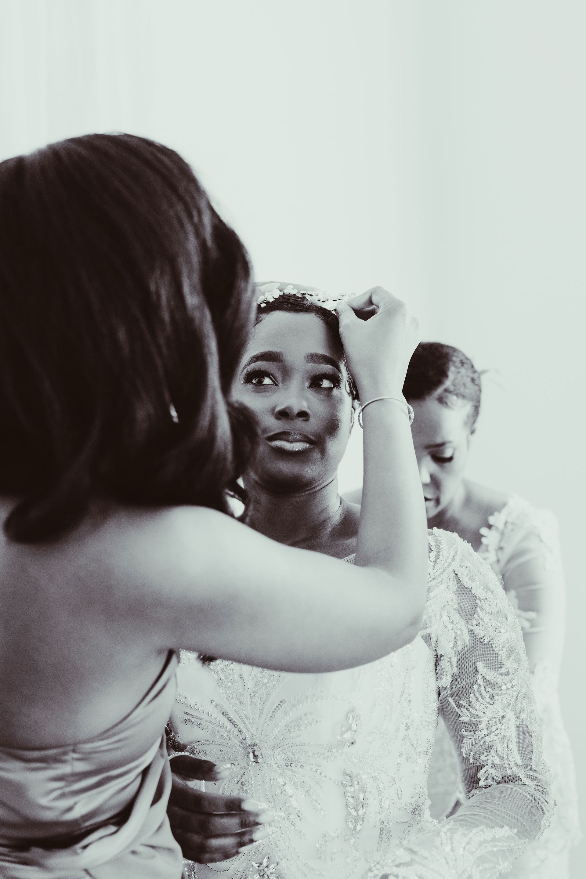 A black and white photo of a bride getting ready for her wedding