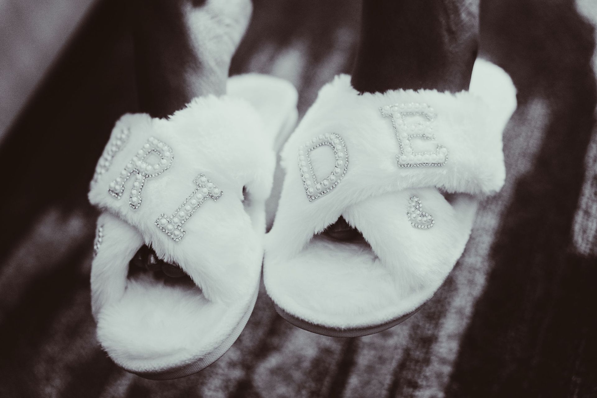 A pair of white slippers with the word love on them.