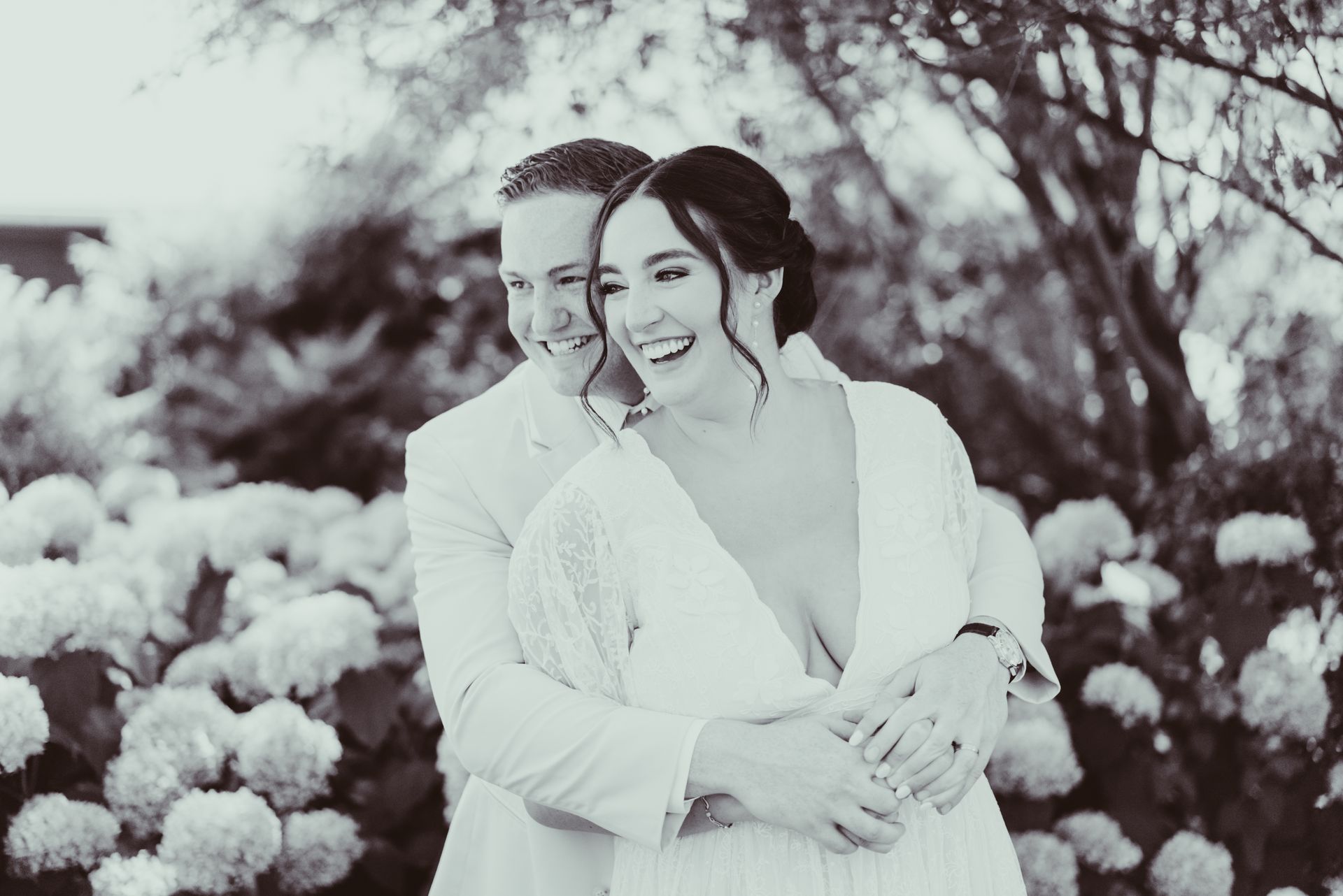 A black and white photo of a bride and groom hugging each other at Jorgensen Farms Oak Grove.