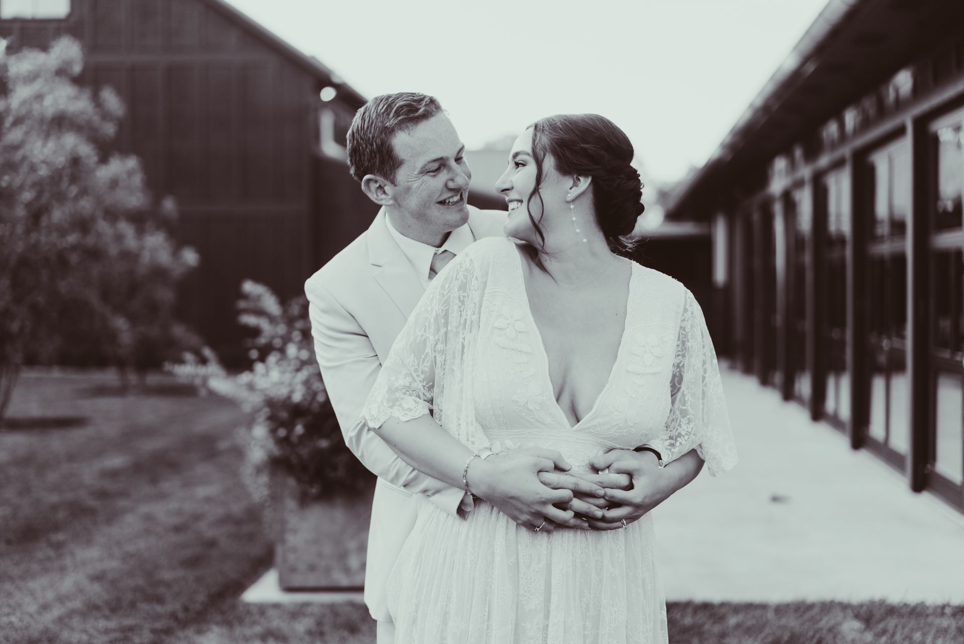 A bride and groom are posing for a black and white photo at Jorgensen farms