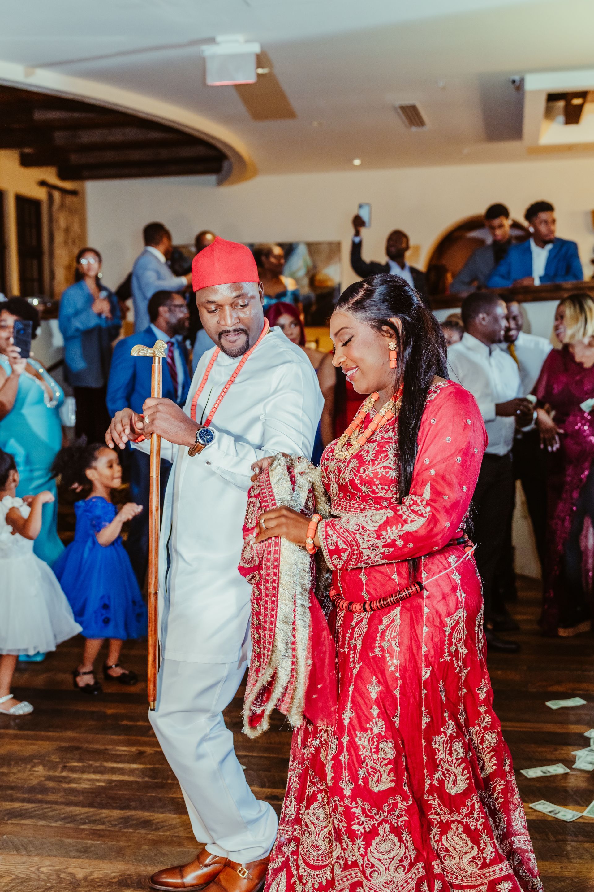 A bride and groom are dancing in front of a crowd at a wedding reception.