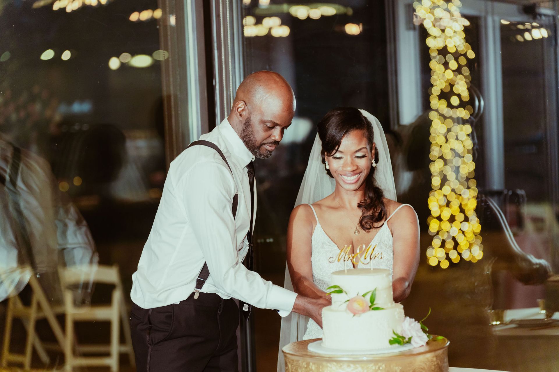 A bride and groom are cutting their wedding cake together.