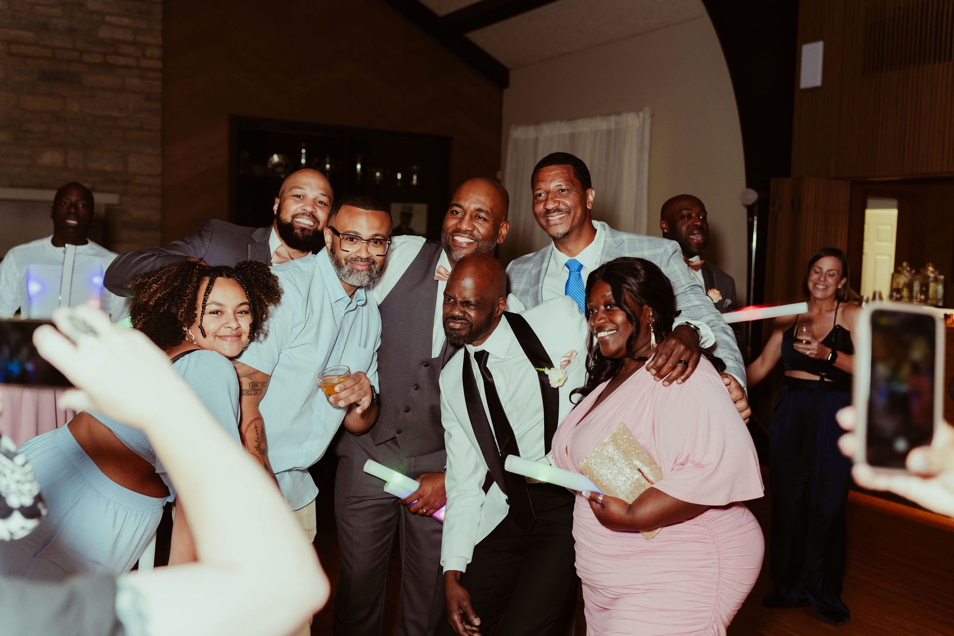 A group of people are posing for a picture at a wedding reception.