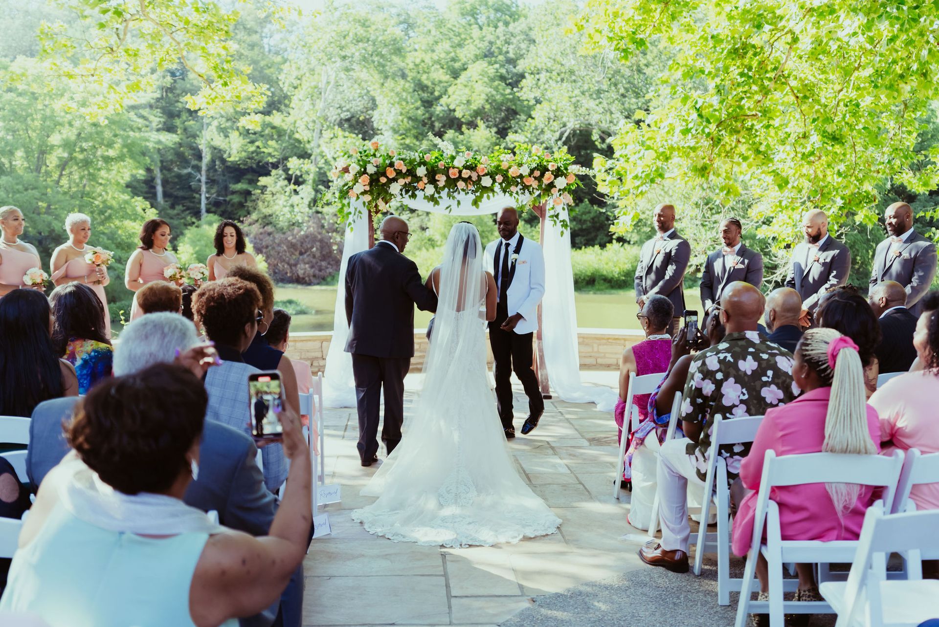 A bride and groom are walking down the aisle at their outdoor wedding ceremony.