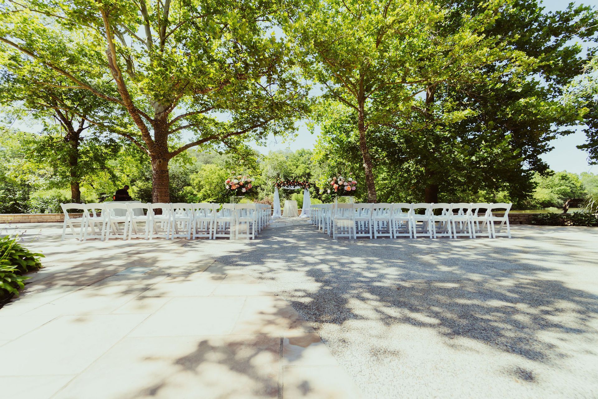 A row of white chairs are lined up in a park.