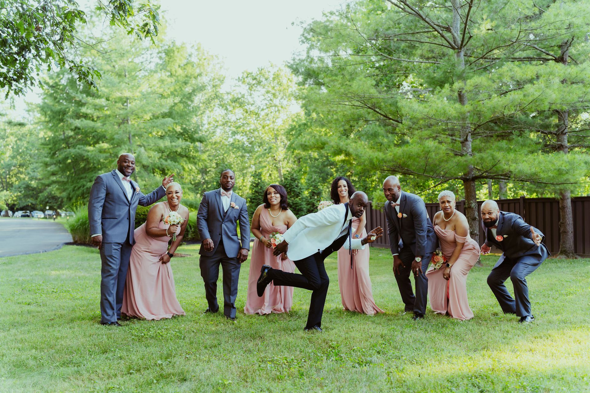 A bride and groom are posing for a picture with their wedding party.