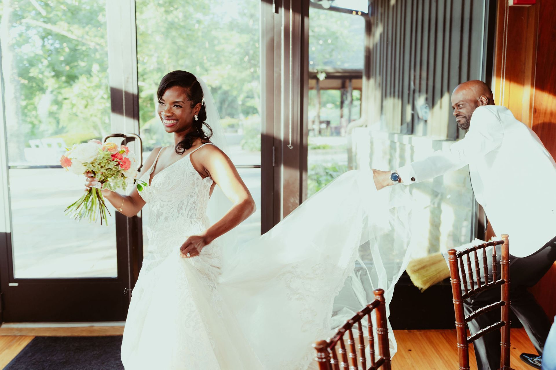 A bride and groom are posing for a picture while the bride 's dress is blowing in the wind.