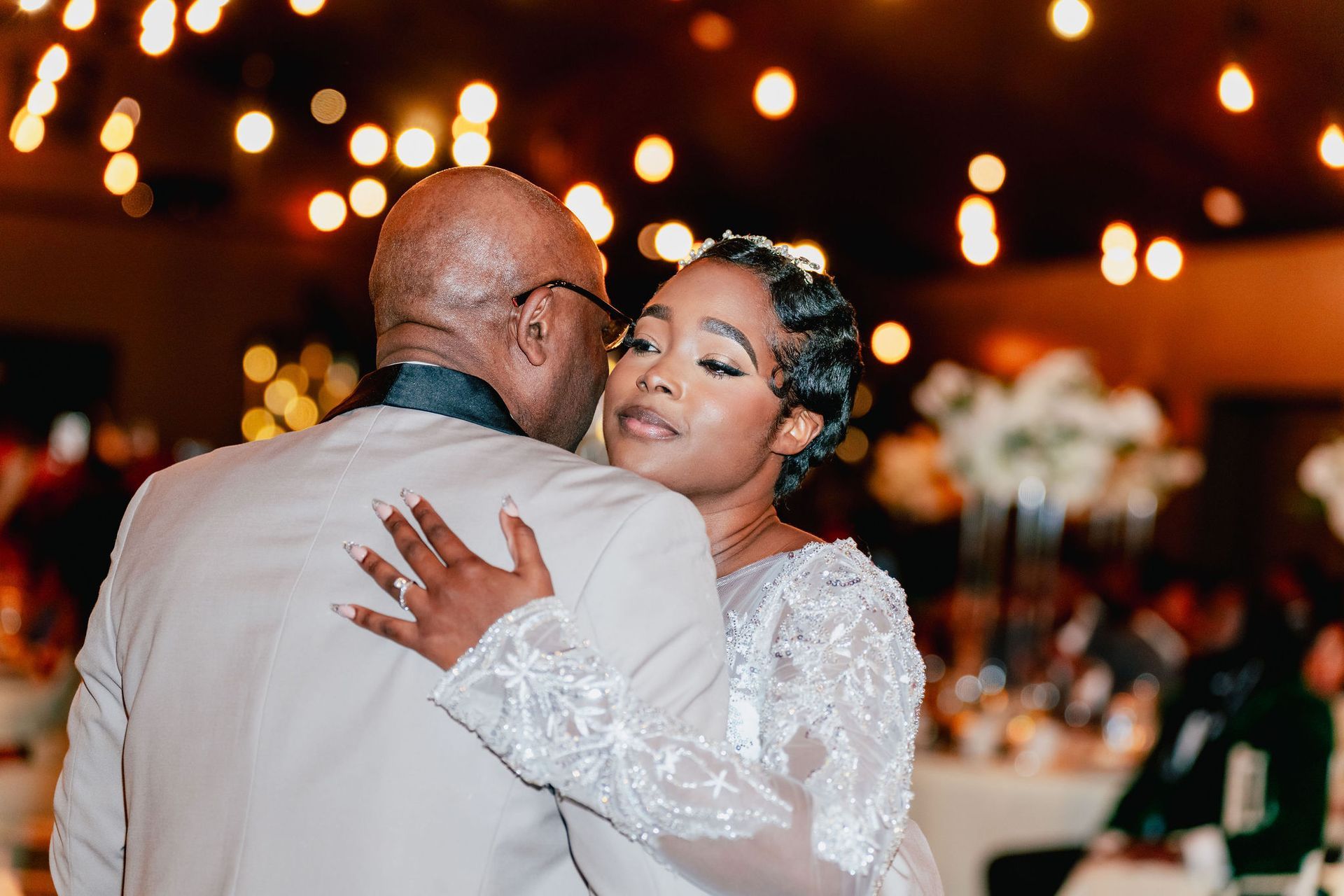 A bride and groom are dancing at their wedding reception.