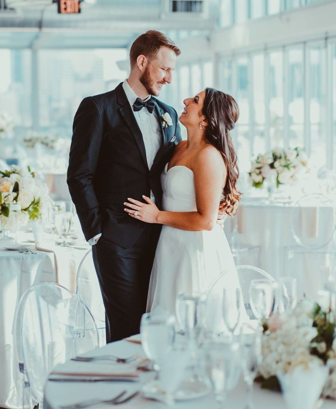 a bride and groom are standing next to each other at a wedding reception .