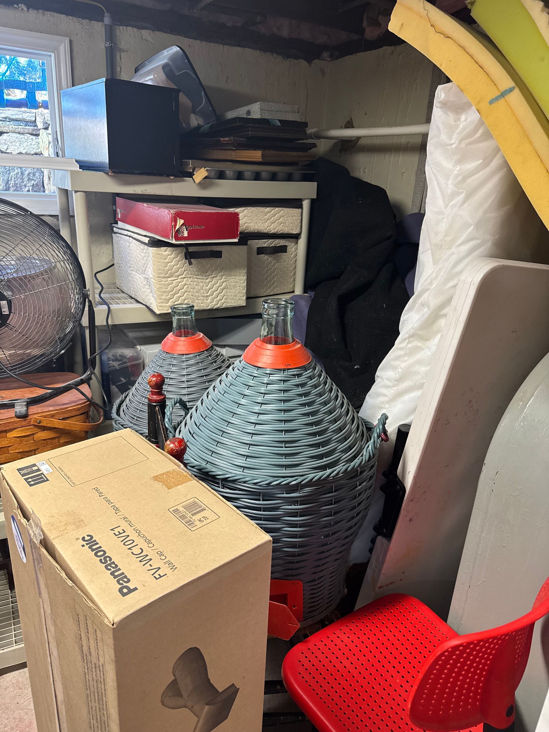 Woman surveys an empty living room with light blue walls, fireplace, and arched window.
