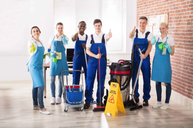 Man in mask and gloves disinfecting a dental office countertop.