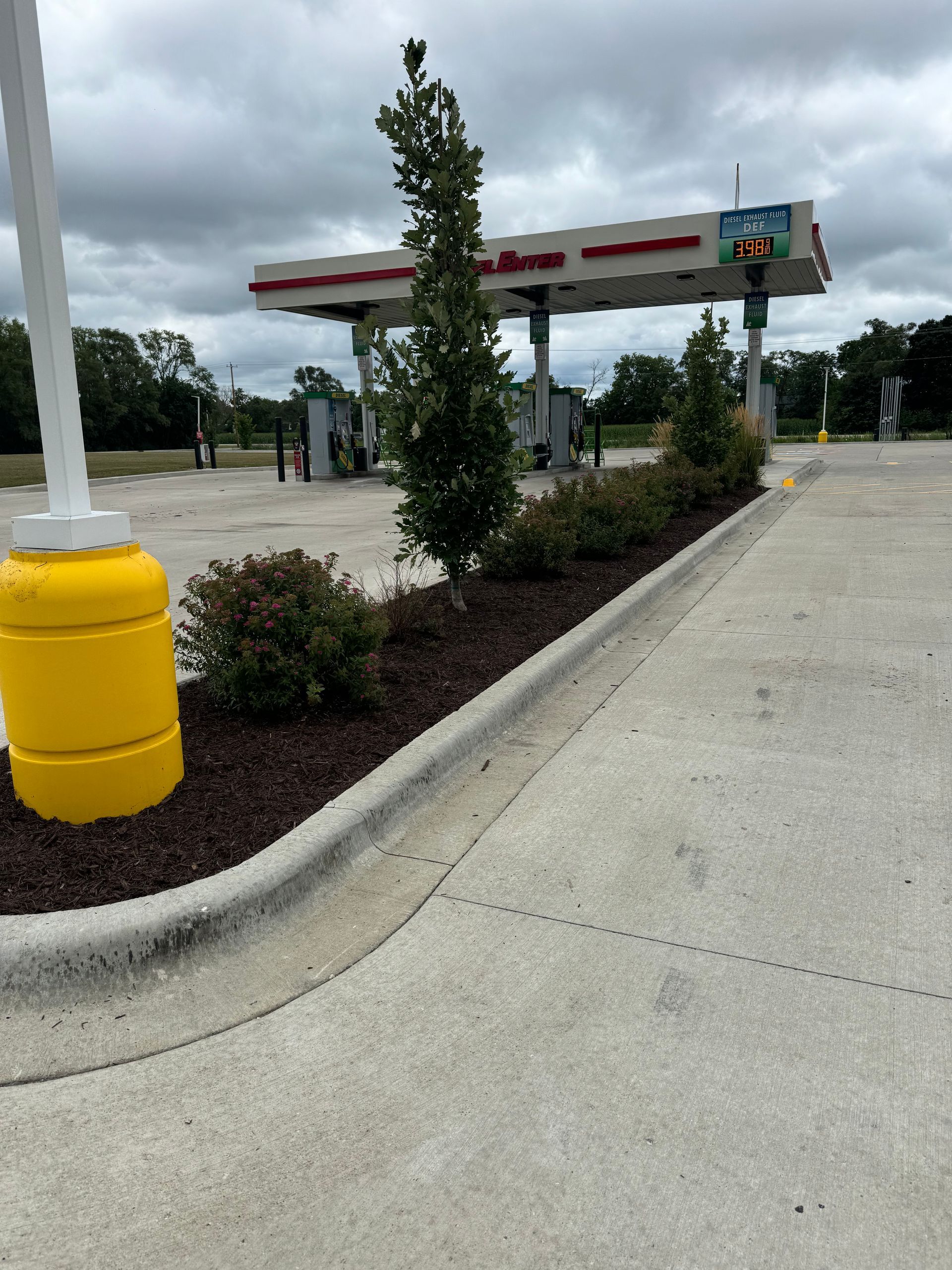 A gas station with a yellow pole in front of it