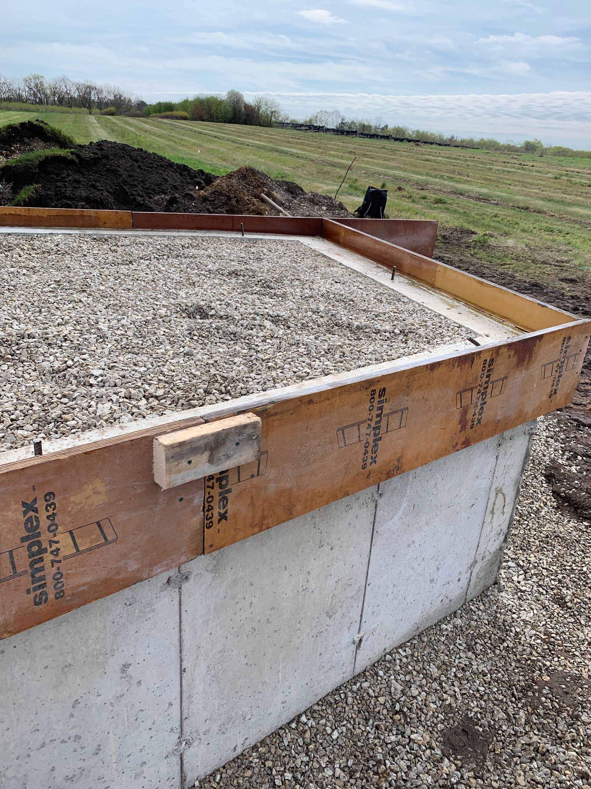 A concrete floor is being poured in front of a house.