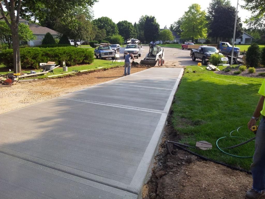 A concrete driveway is being built in a residential area