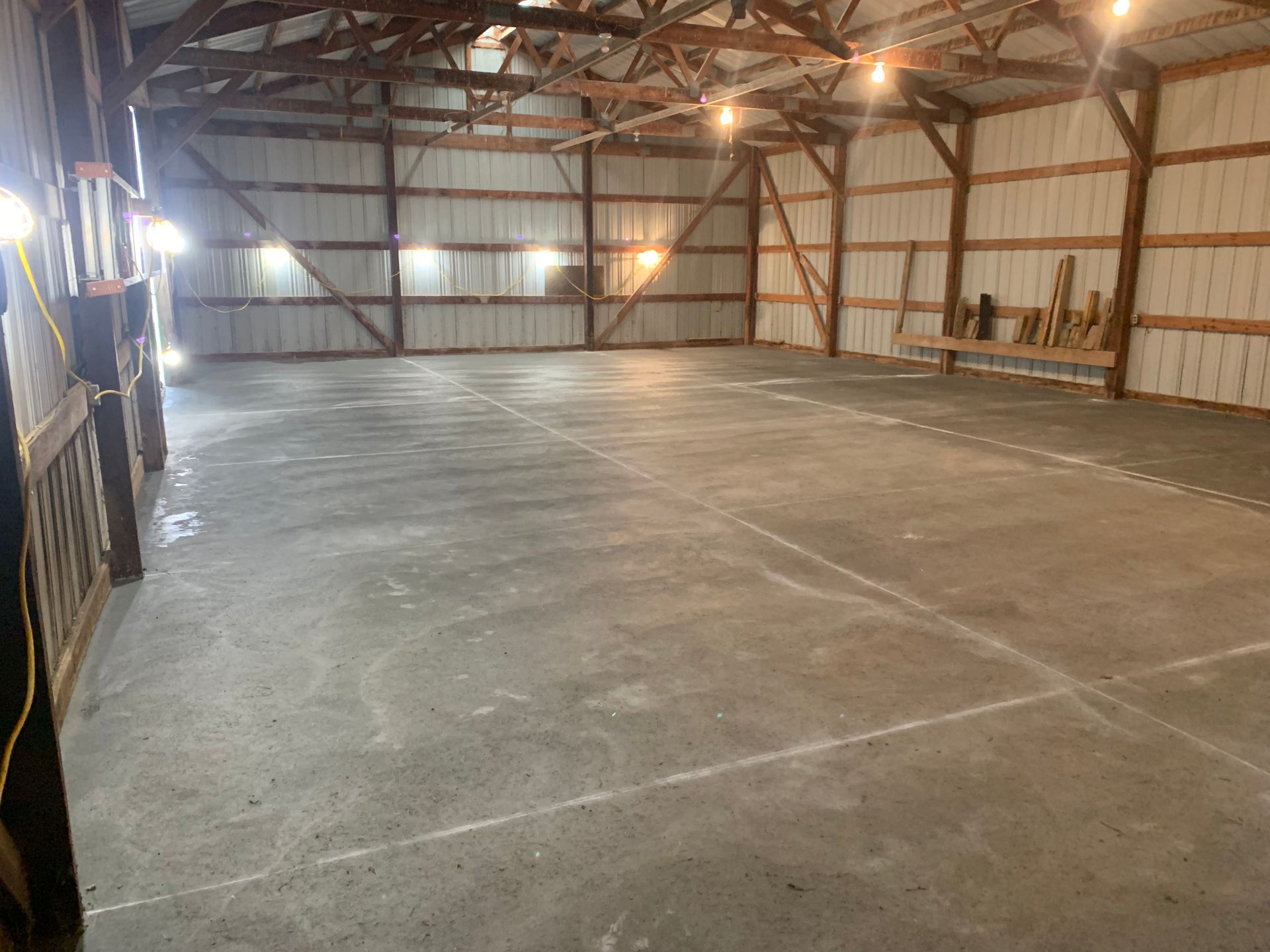 A large empty warehouse with a concrete floor and wooden walls.